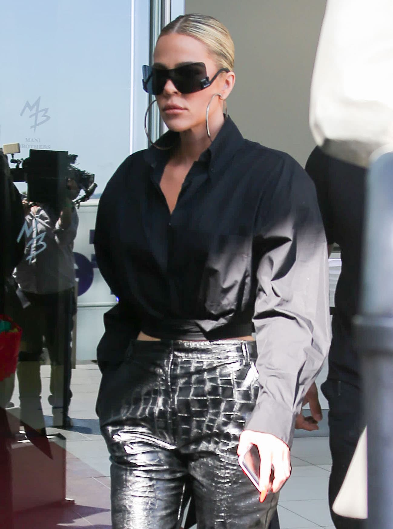 Khloe Kardashian styles her monochromatic black outfit with futuristic Versace sunglasses