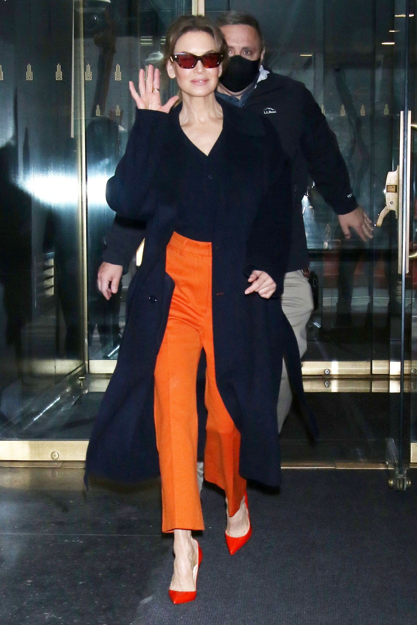 Renée Zellweger in Max Mara sweater, orange pants, and black coat ahead of her appearance on the Today Show