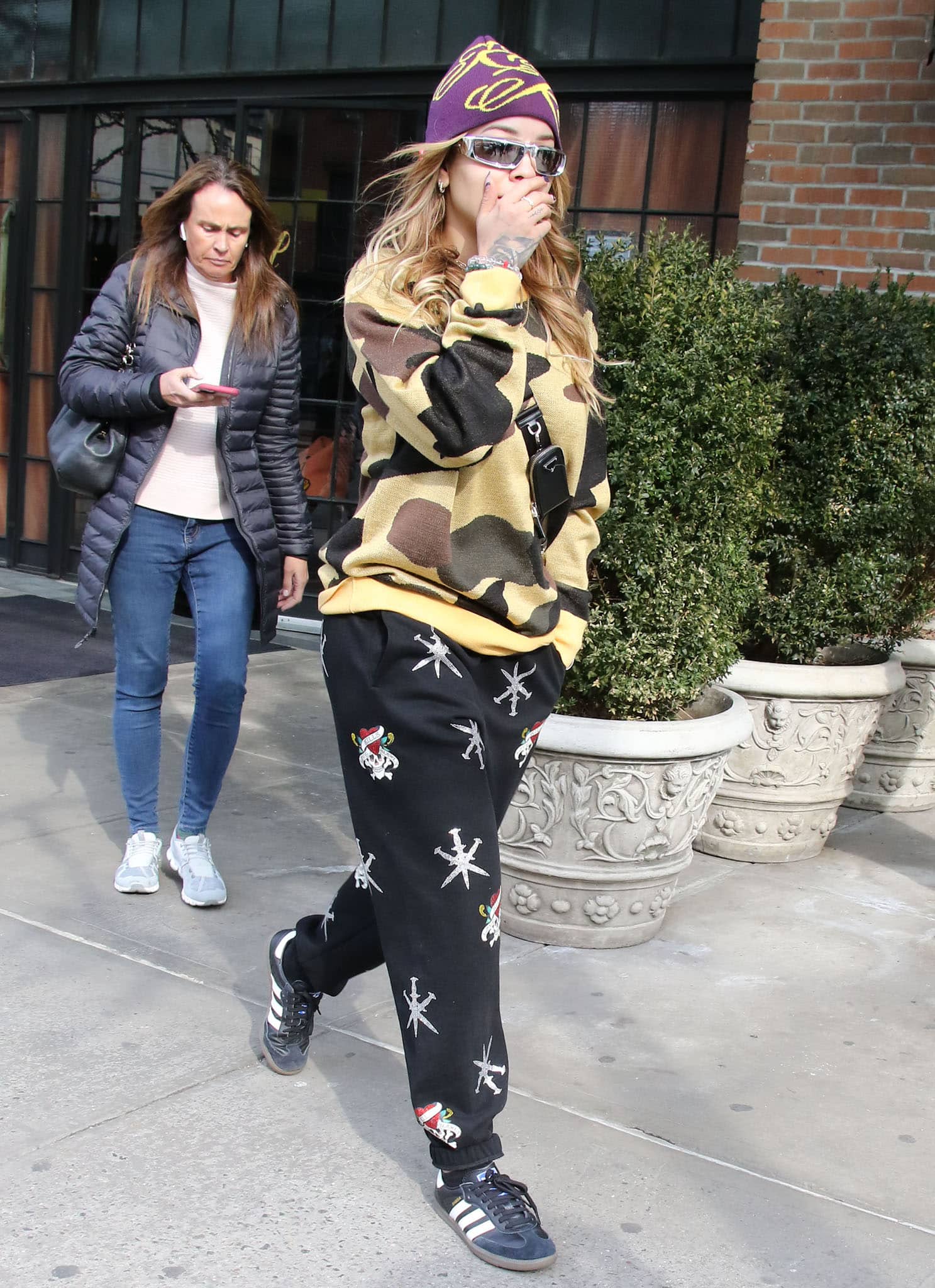 Rita Ora steps out of the Bowery Hotel in Bape camo sweater and Unknown x Ed Hardy joggers on March 10, 2022