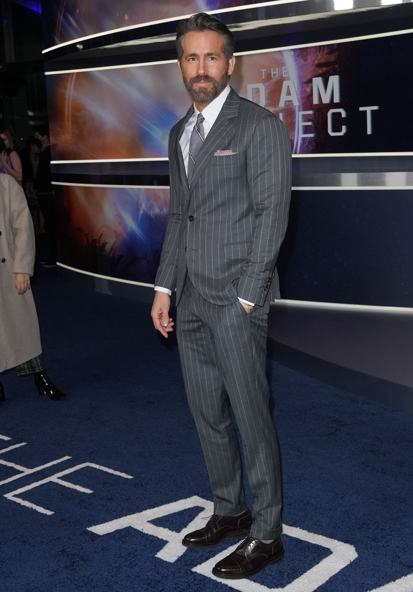 Ryan Reynolds looks dashing in his charcoal pinstriped suit and matching tie