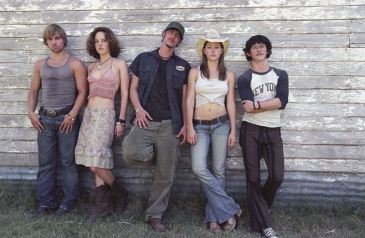 Jessica Biel (Erin Hardesty) anchors the group’s early-2000s road-trip style in cowboy boots and low-rise jeans, joined by Mike Vogel (Andy) in worn-in boots, Erica Leerhsen (Pepper) in rustic Western boots, Eric Balfour (Kemper) in rugged lace-ups, and Jonathan Tucker (Morgan) in casual sneakers in The Texas Chainsaw Massacre (2003)