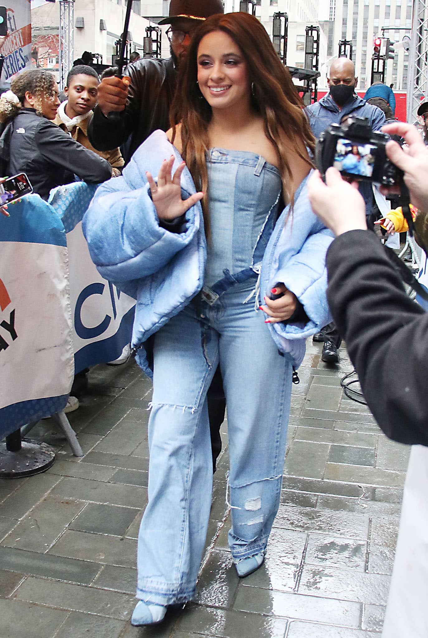 Camila Cabello wears a strapless denim corset top by Denimcratic with a denim puffer jacket, matching distressed wide-leg jeans, and denim heels