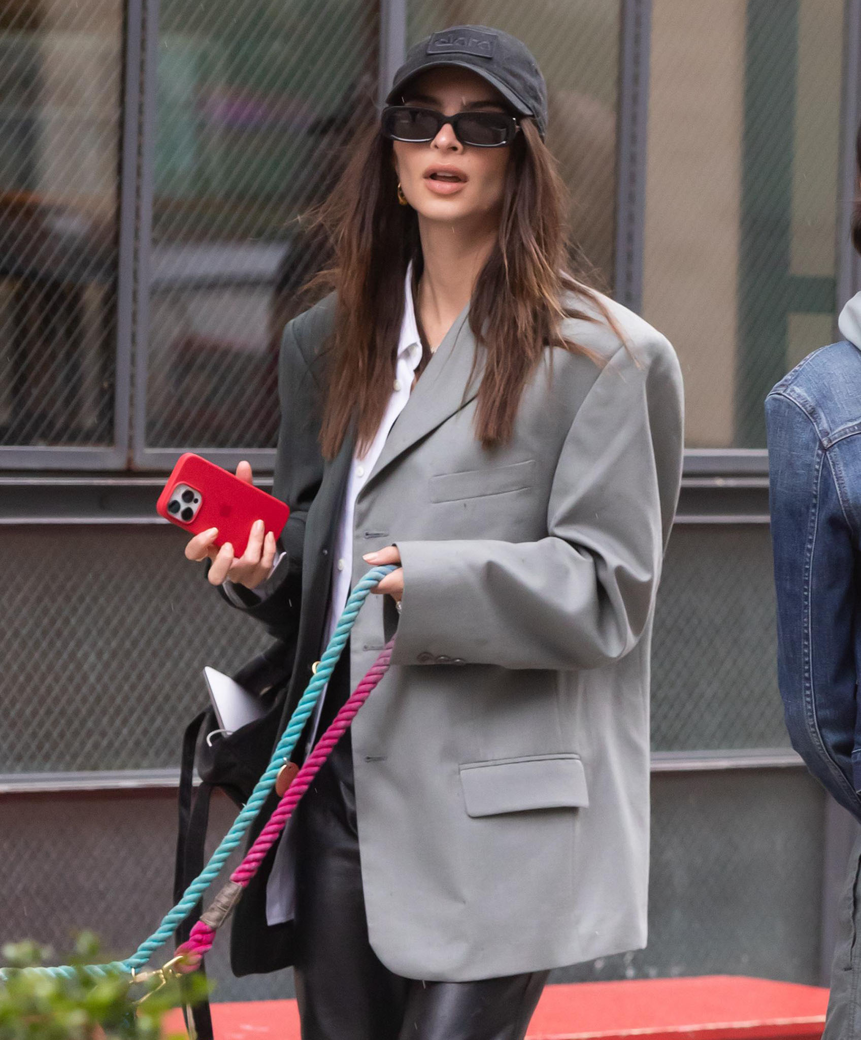 Emily Ratajkowski keeps a low-key look with a black baseball cap and a pair of rectangular sunglasses