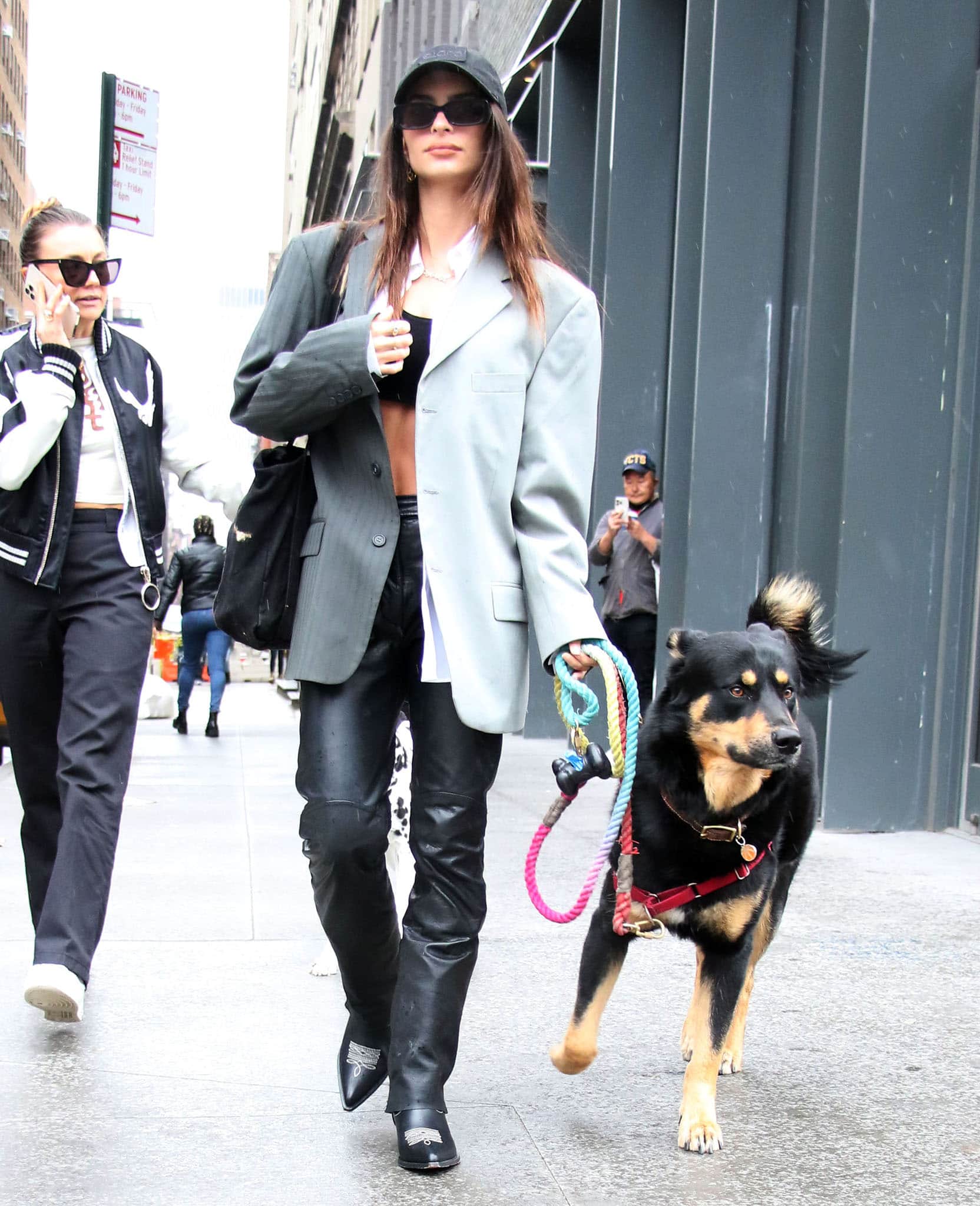 Emily Ratajkowski walks her dog, Colombo, in a black All Fenix bra top, an open white shirt, and a color-block blazer