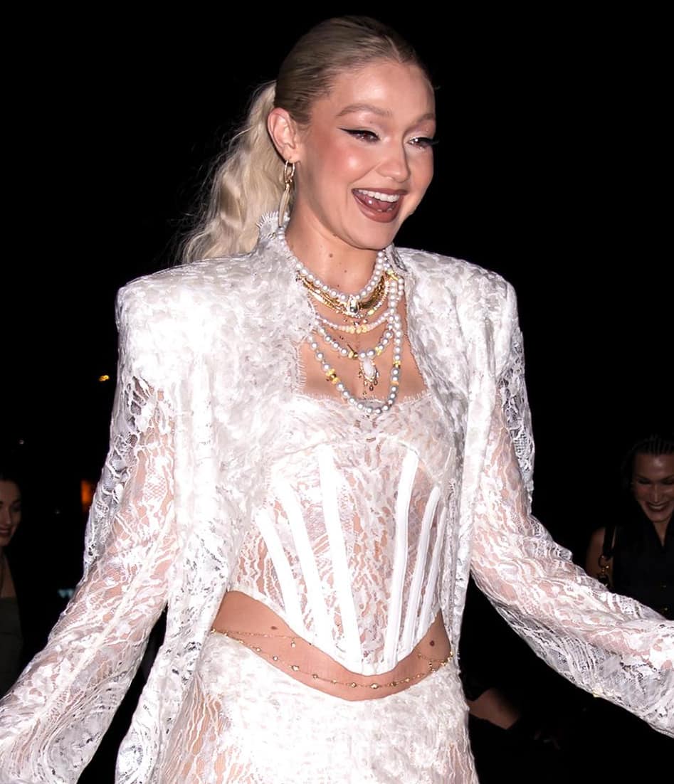Gigi Hadid accessorizes with layers of pearl necklaces, a body chain, a belly chain, and multiple rings, all from Jacquie Aiche