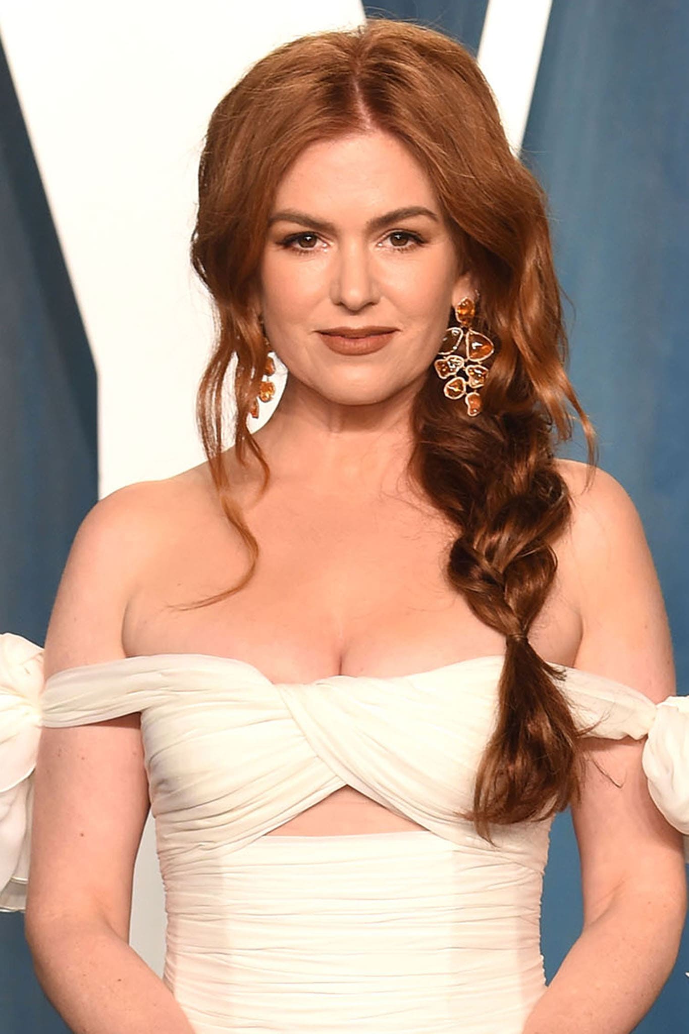 Isla Fisher wears nude makeup and styles her hair in a loose fishtail braid