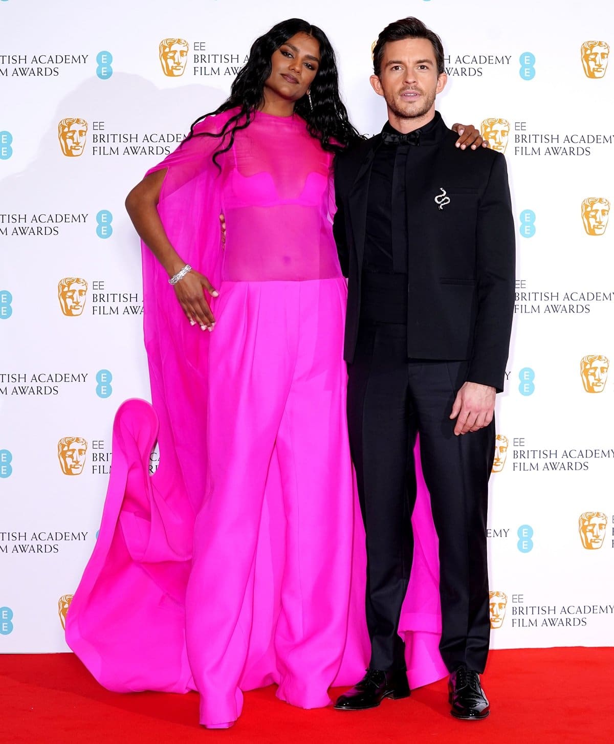 Simone Ashley in a pink Valentino dress and her Bridgerton co-star Jonathan Bailey in Dior at the 2022 EE British Academy Film Awards
