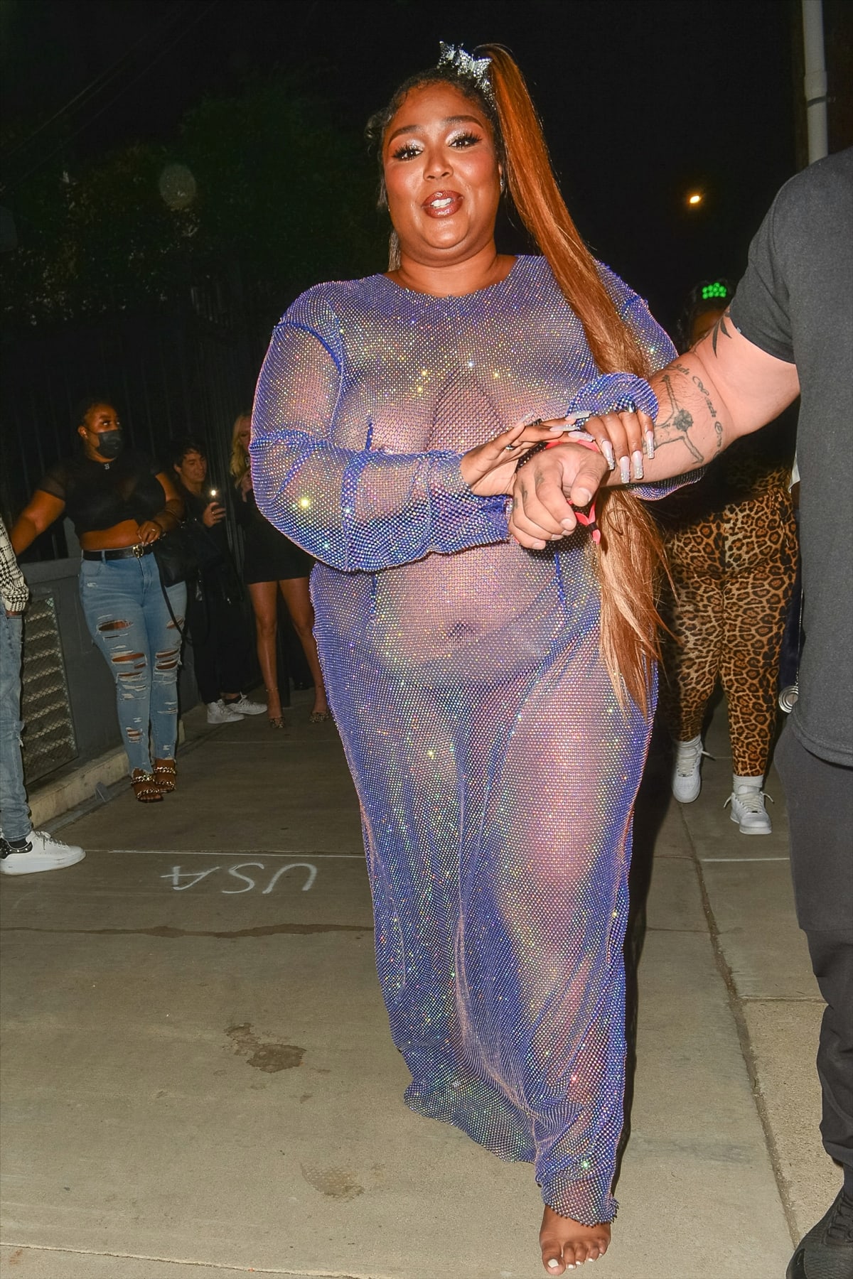 Lizzo wears a sheer blue dress leaving Cardi B‘s dance-hall-themed 29th birthday party