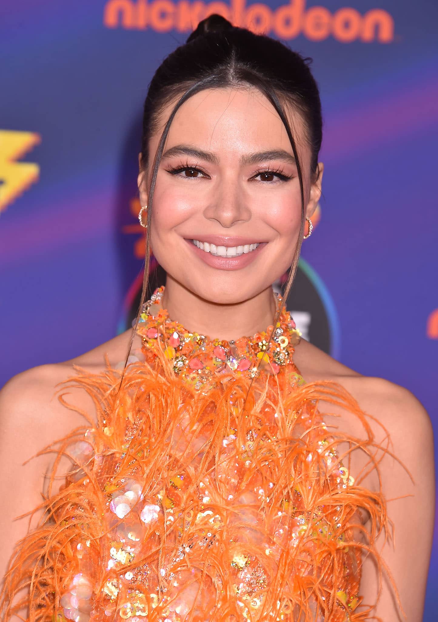 Miranda Cosgrove styles her tresses in a chic updo and wears nude makeup with fake lashes