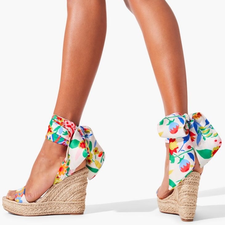 A braided outsole lends beachy flair to these Christian Louboutin Monica Du Desert wedge sandals with a floral printed ankle tie
