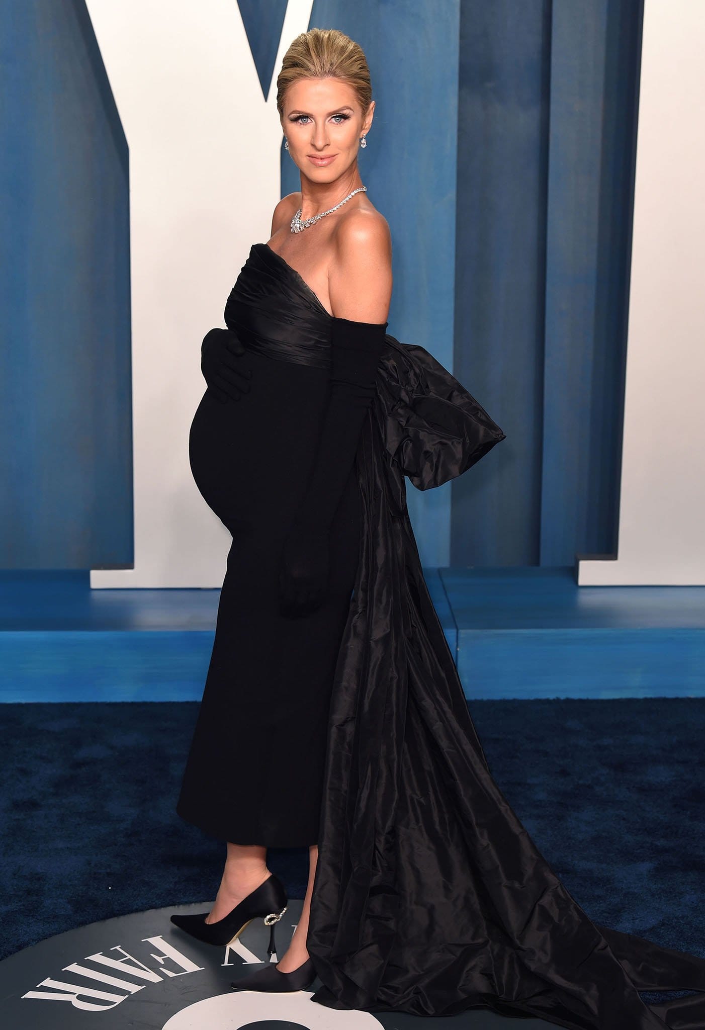 Nicky Hilton showcases her baby bump in a custom form-fitting Oscar de la Renta gown and a pair of Mach and Mach pumps with crystal bow-detailed heels