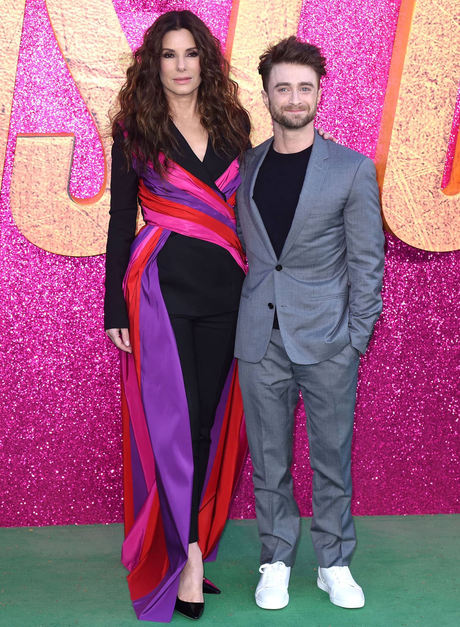 Sandra Bullock towers over Daniel Radcliffe who was clad in a gray suit and a black knit sweater