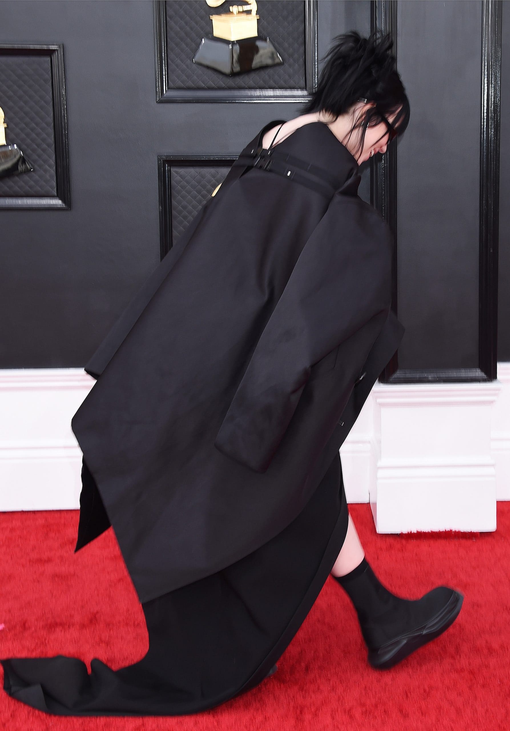 Billie Eilish styled a black floor-length dress with a long trench coat and rubber-soled black platform boots