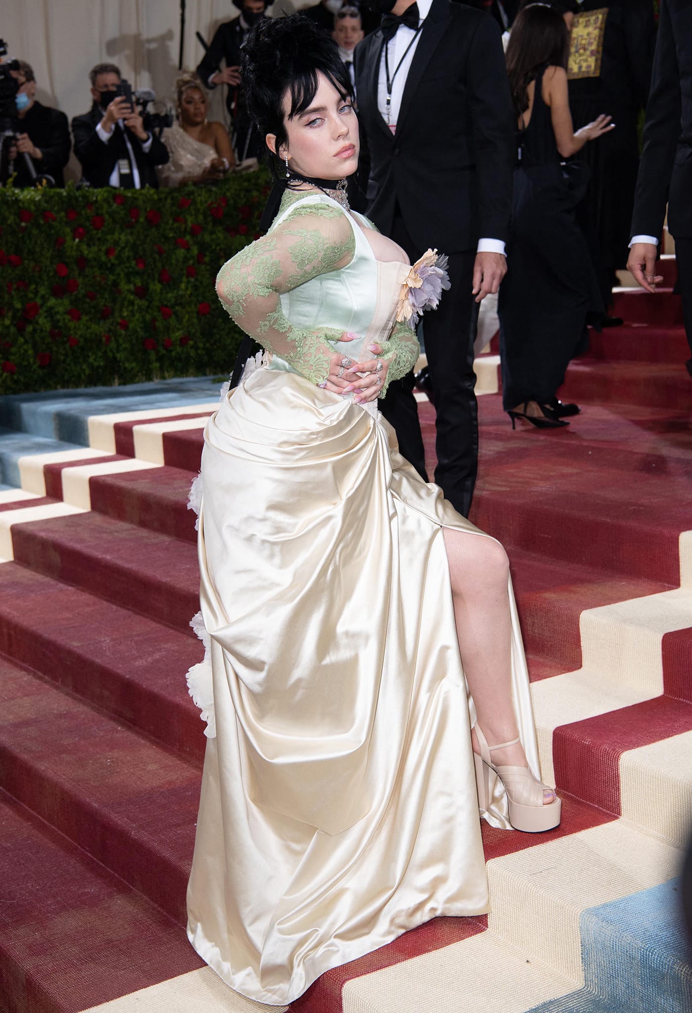 Billie Eilish's gown was made using ivory and duchesse satin with a gathered ivory skirt, padded bustle, and green sheer lace underlay and long sleeves