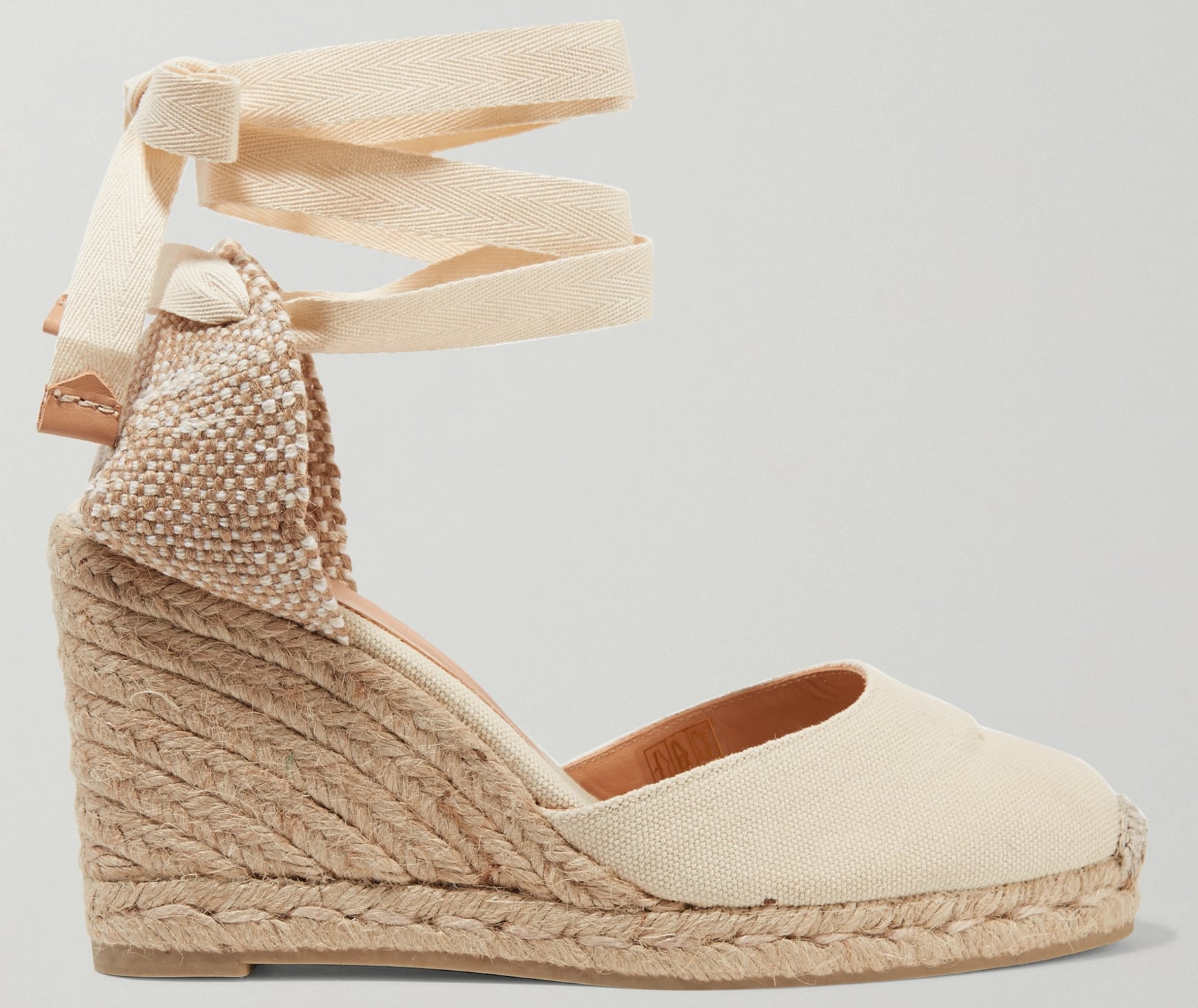 The Castaner Carina features a canvas upper, lace-up straps, and jute wedge heels