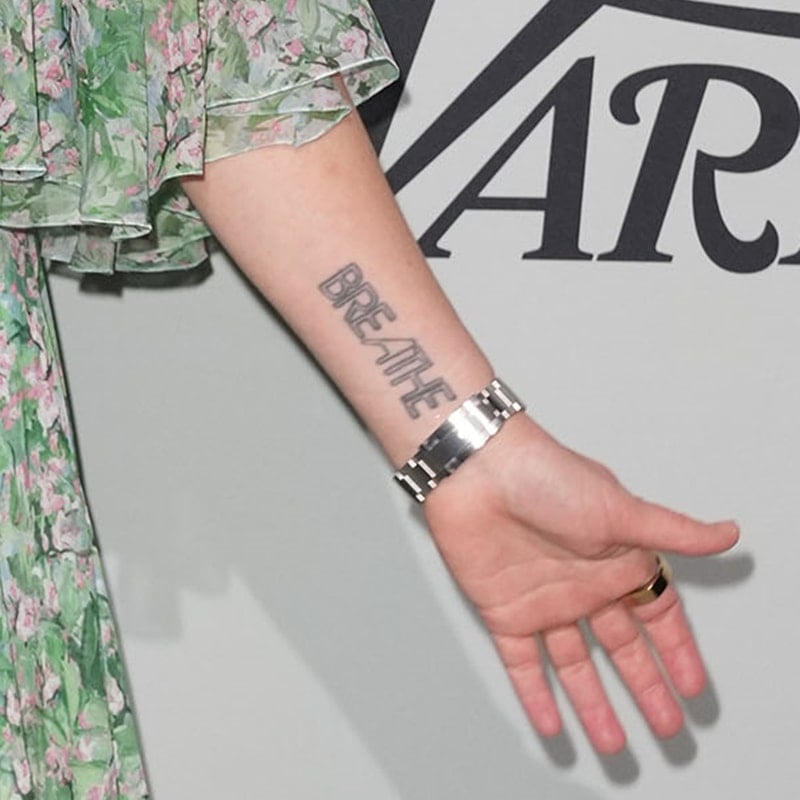 Drew Barrymore's BREATHE tattoo on her left forearm reminds her to stay calm and level-headed
