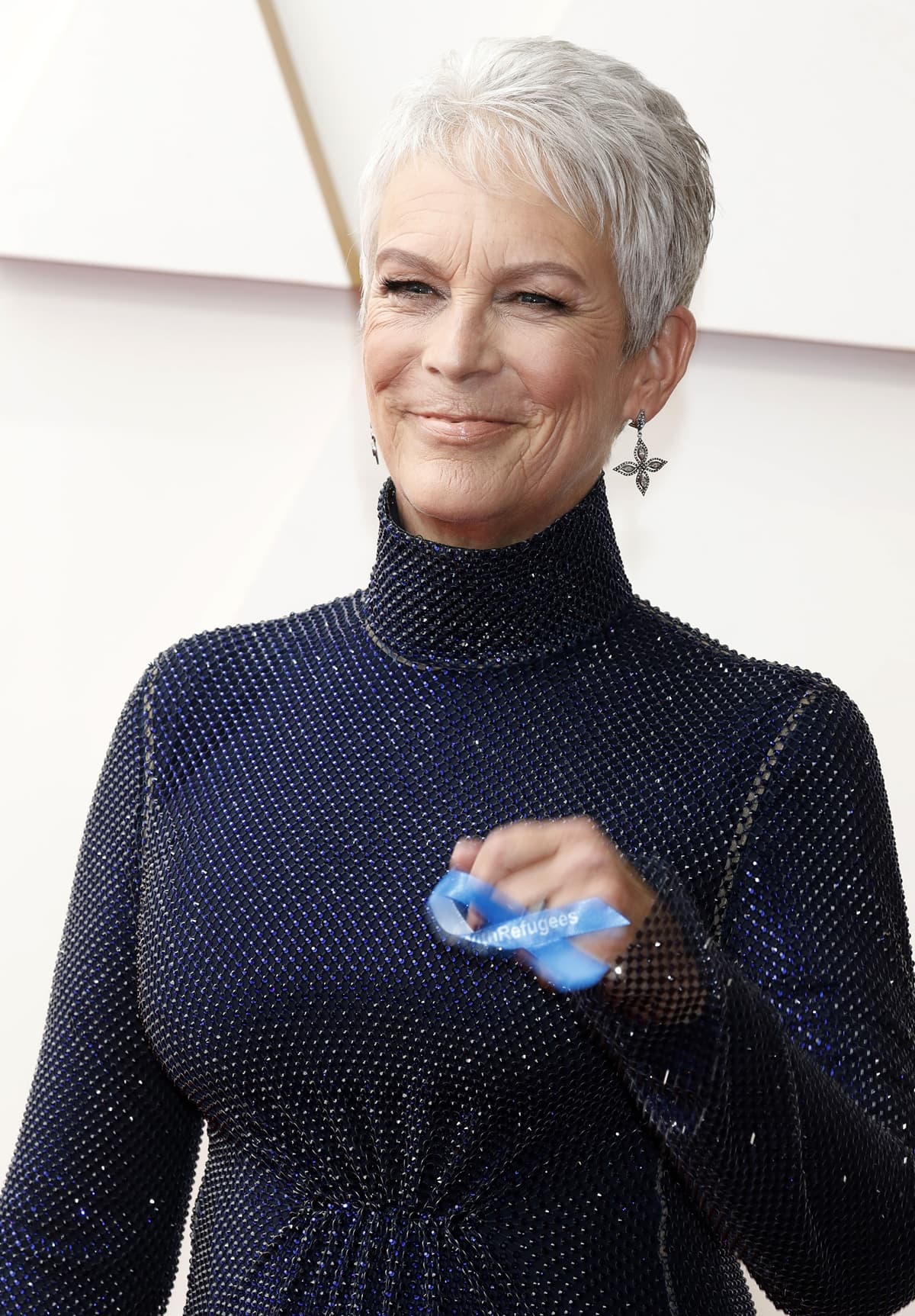 Jamie Lee Curtis shows off her Cathy Waterman ethically sourced diamond marquise star earrings and blue “Stand With Refugees” ribbon