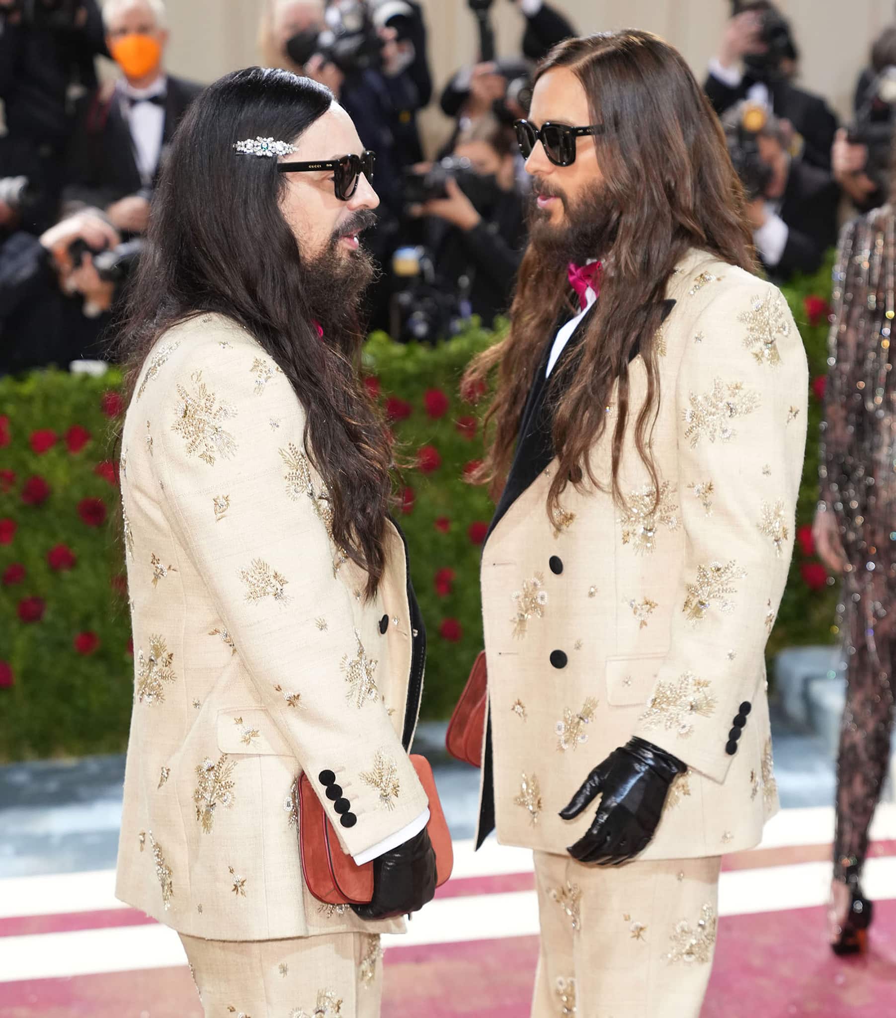 Alessandro Michele and Jared Leto complete their matching outfit with red bow ties, Gucci clutches, and black leather gloves