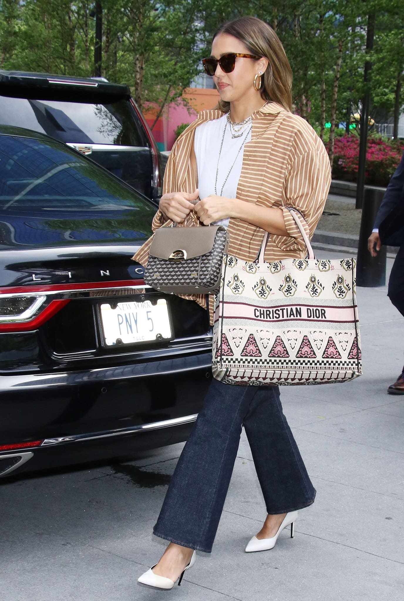 Jessica Alba opts for business-casual in a white tee, Dissh's striped shirt, and flared jeans