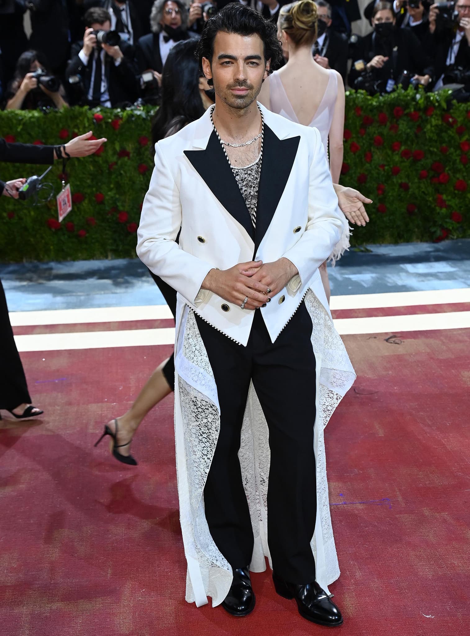 Joe Jonas dons a womenswear whitetail jacket and lacy top with a white tuxedo