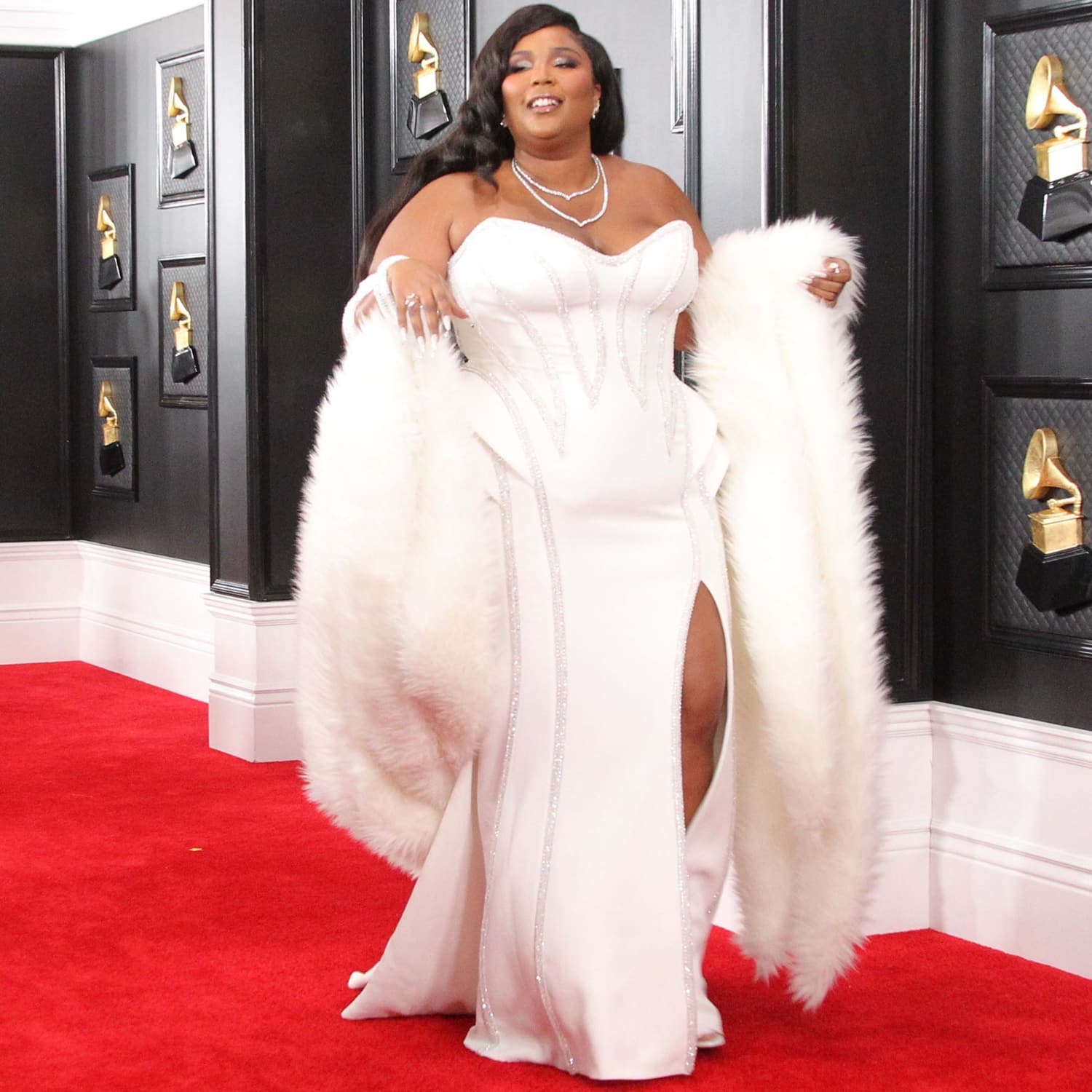 Lizzo wears a white Atelier Versace gown with Lorraine Schwartz jewelry and René Caovilla ‘Cleo’ sandals at the 62nd Annual GRAMMY Awards
