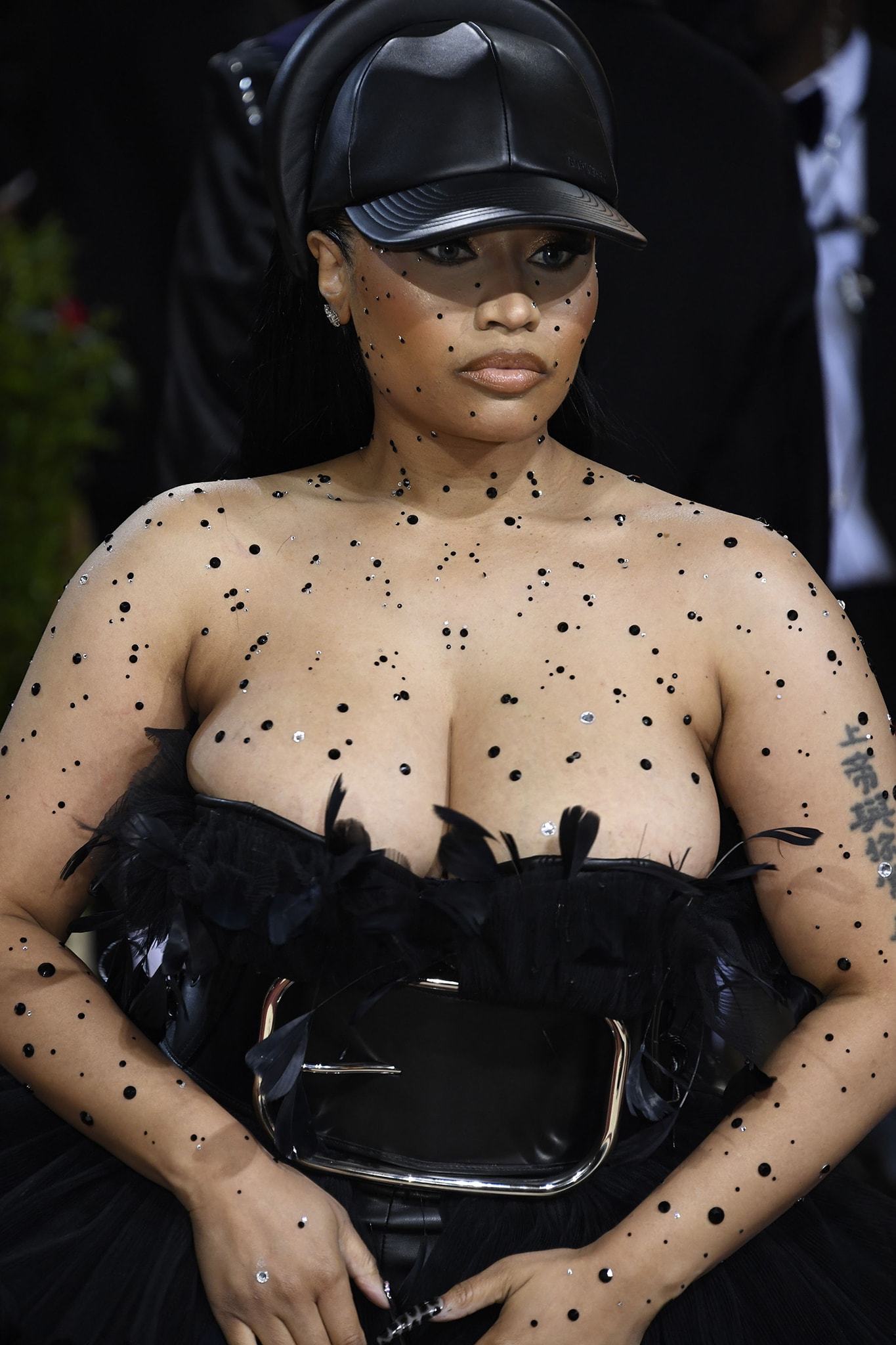 Nicki Minaj has tiny black jewels added to her neck and arms for a Black Swan inspired look