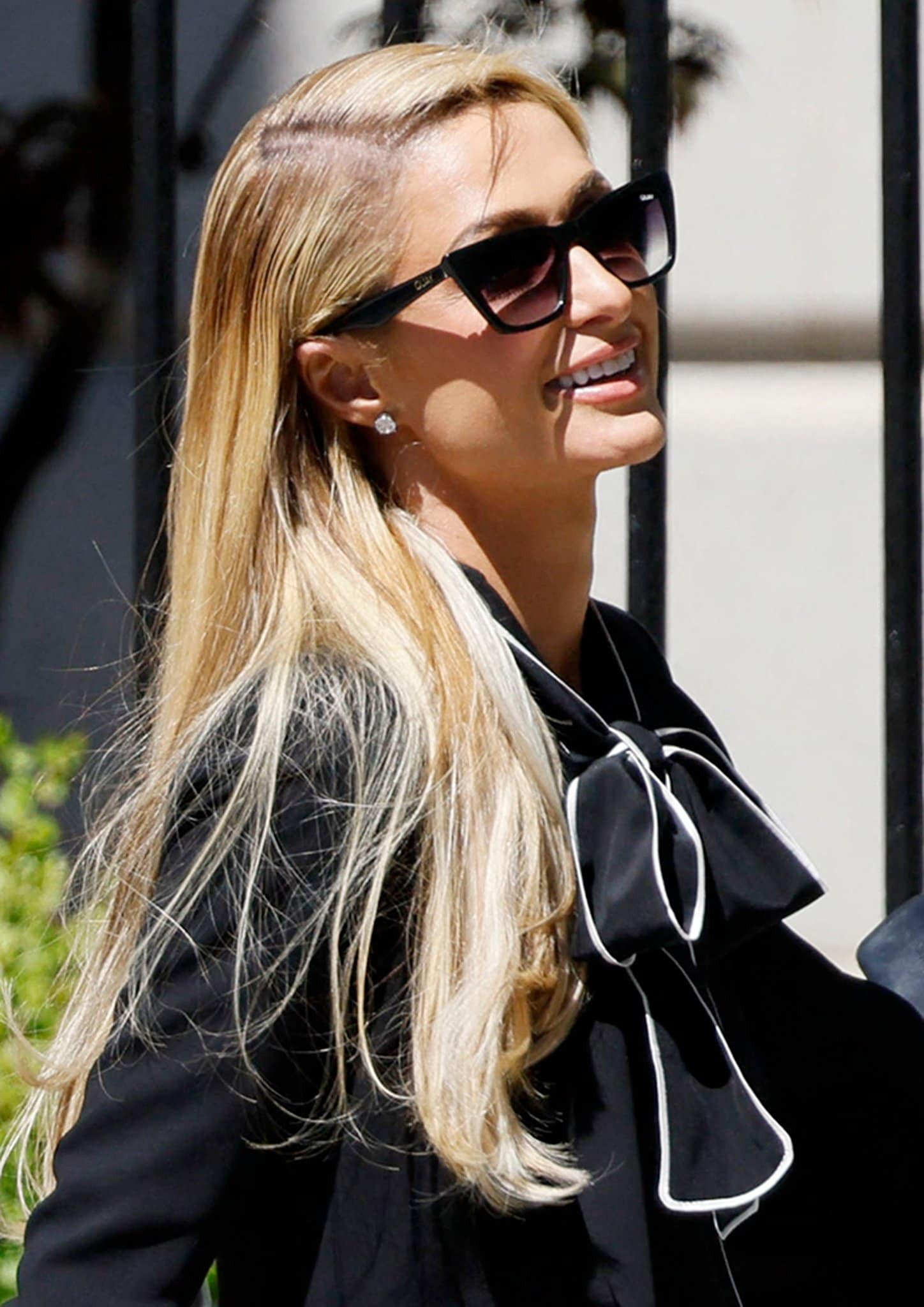 Paris Hilton styles her look with Quay Australia sunnies and diamond stud earrings