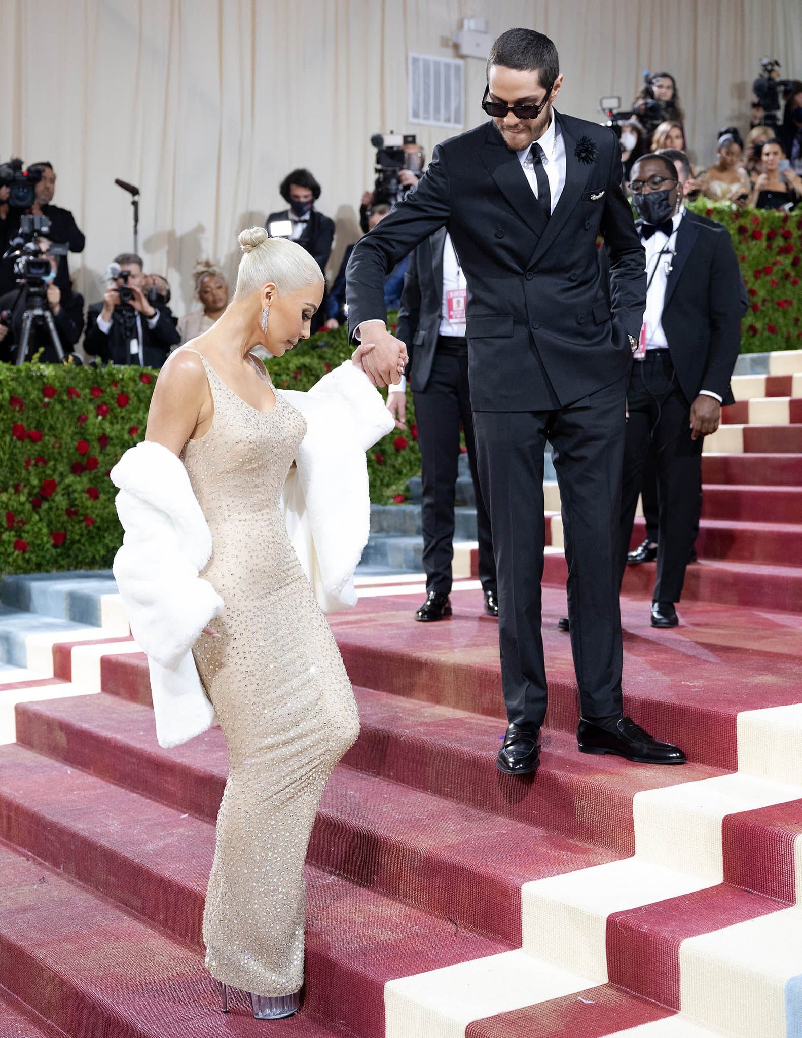Pete Davidson helps Kim Kardashian as she takes tiny steps on the Grand Staircase at the Metropolitan Museum of Art