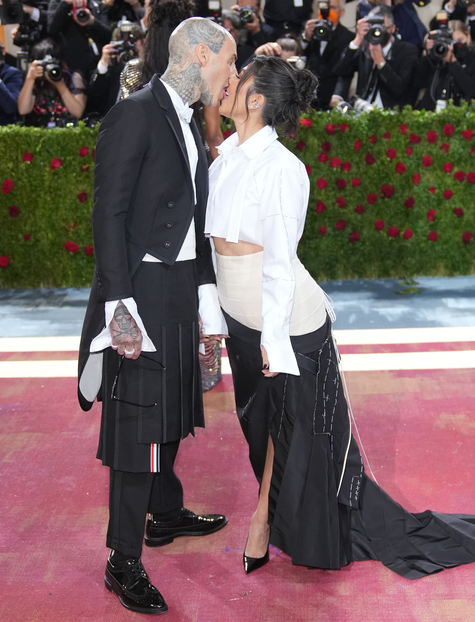 Travis Barker and Kourtney Kardashian share sloppy kisses at the Met Gala on May 2, 2022