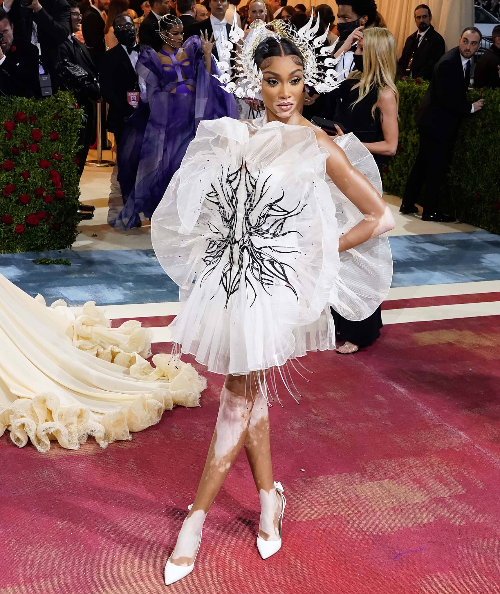 Winnie Harlow pairs her 3D floral mini dress with a kinetic crown headpiece
