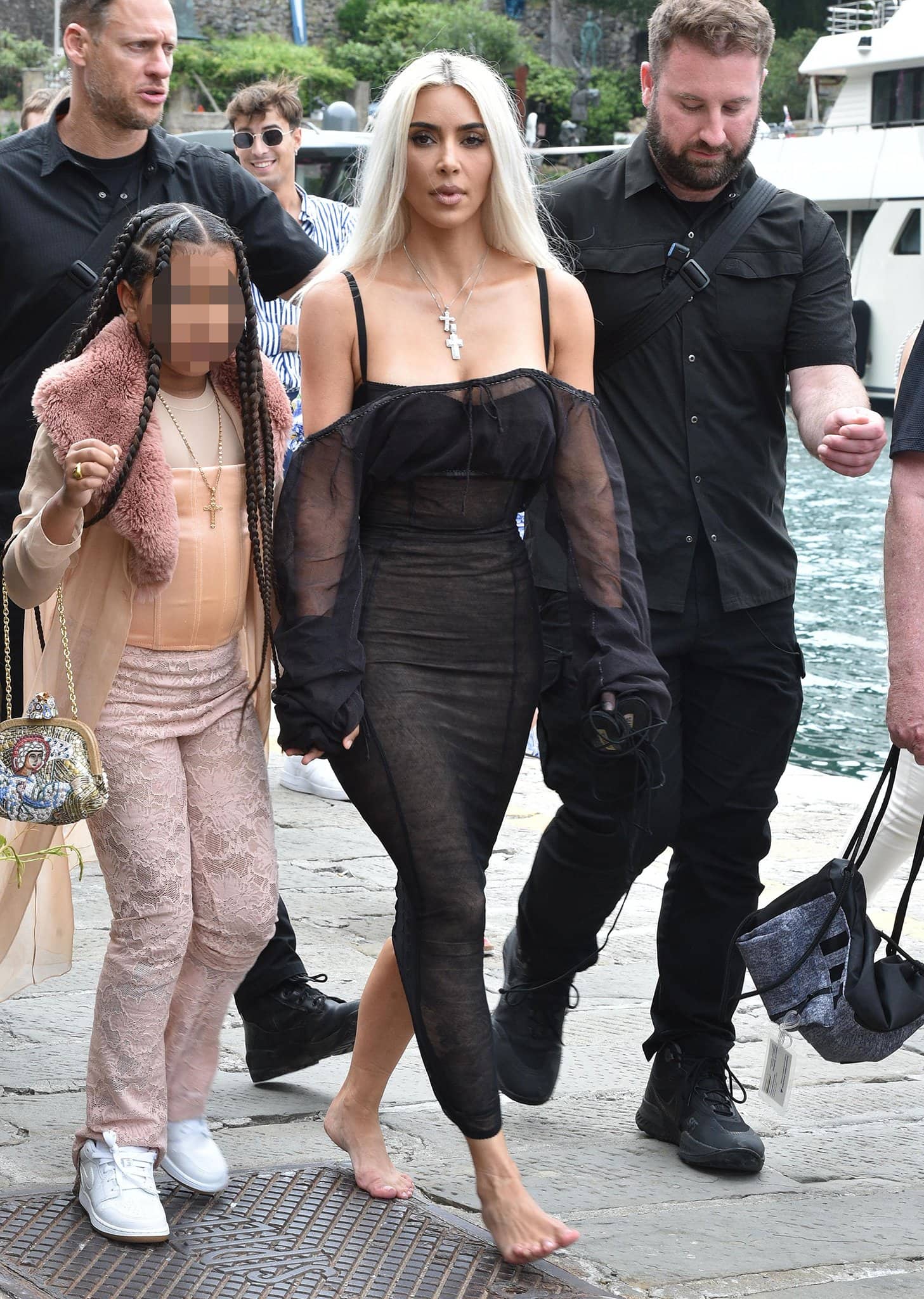 Barefoot Kim Kardashian holds hands with daughter North clad in pink lace trousers and a peach corset