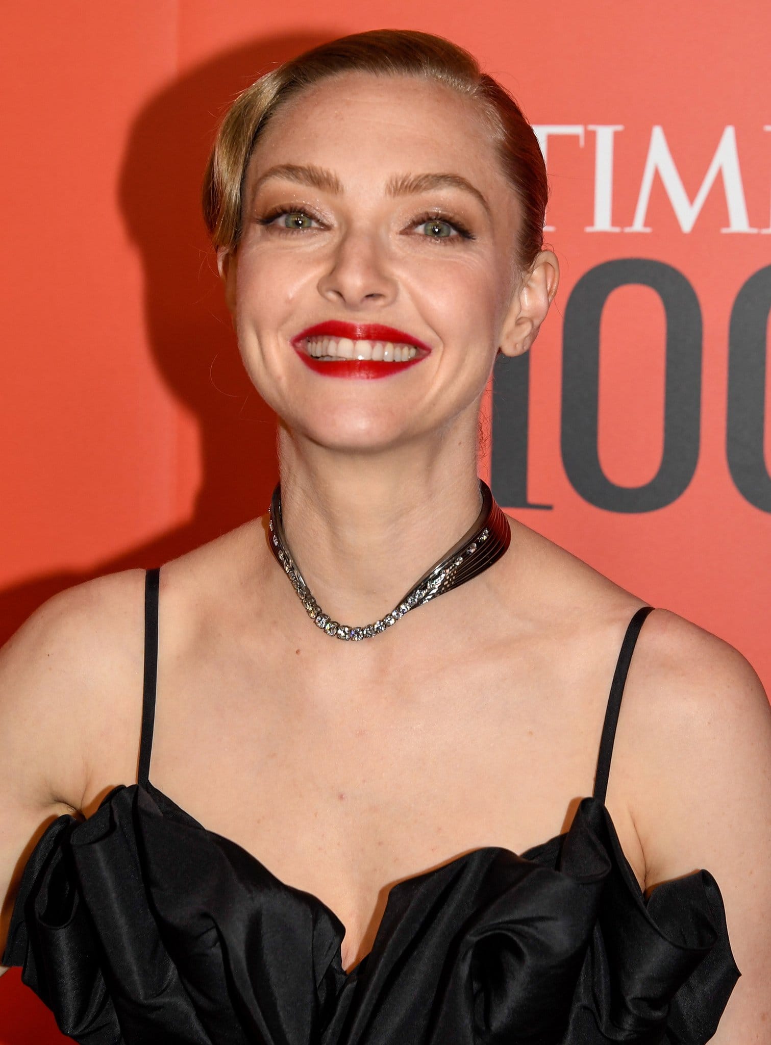 Amanda Seyfried adds a custom Almasika necklace and a swipe of bold red lip color to her black ensemble