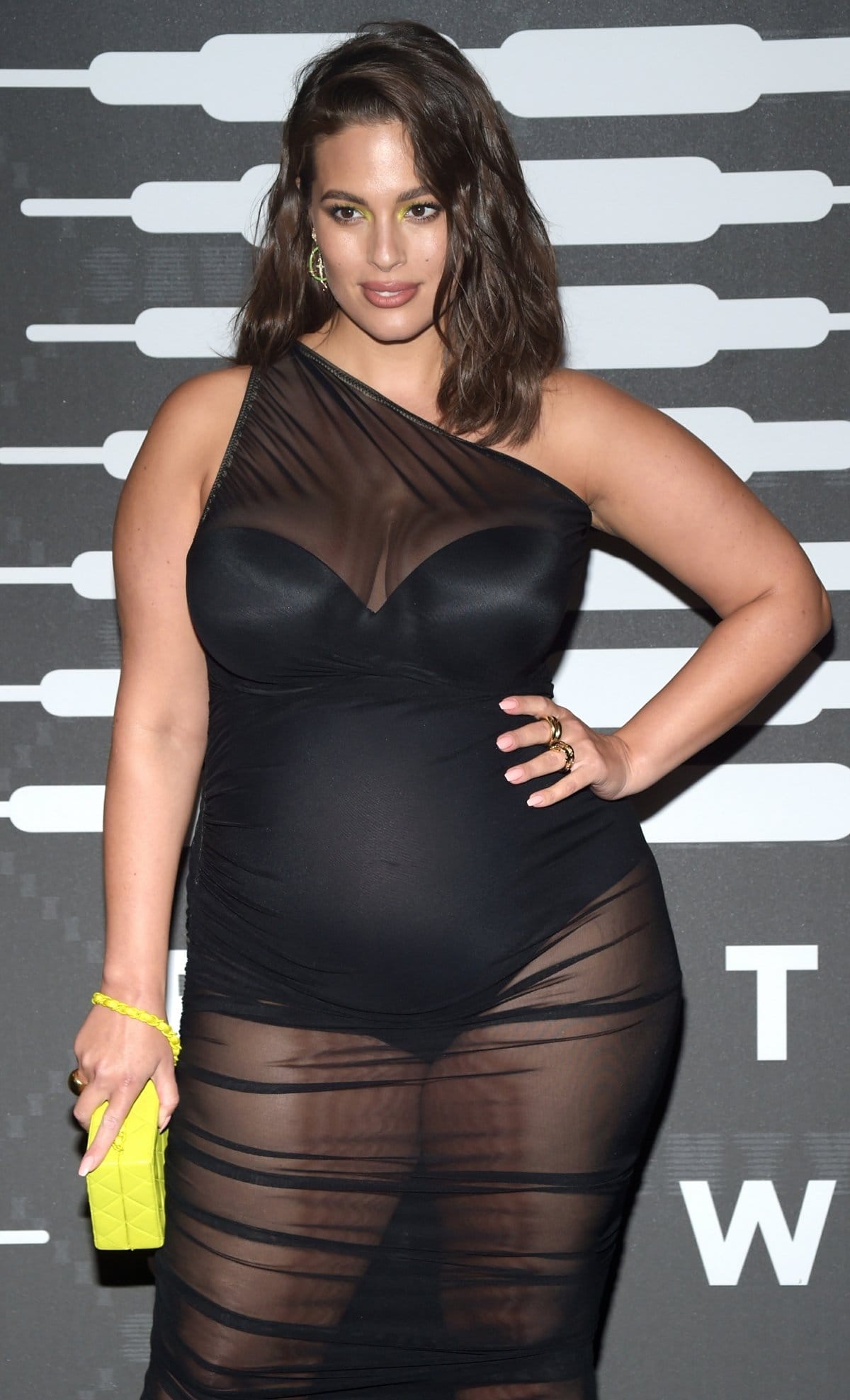 Ashley Graham carries a vintage Chanel bag from What Goes Around Come Around and shows off her baby bump at the Savage X Fenty fashion show