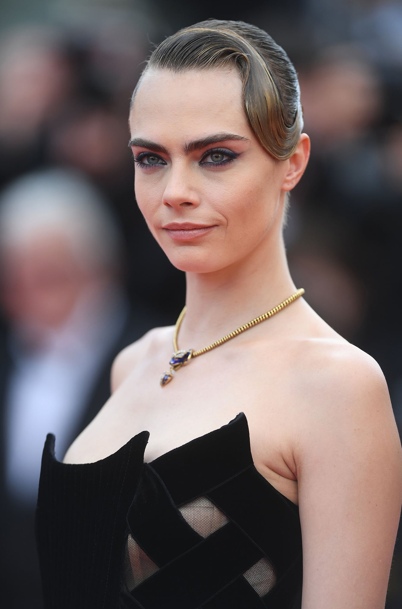 Cara Delevingne wears smokey eye-makeup and a slick 1920s finger wave hairstyle