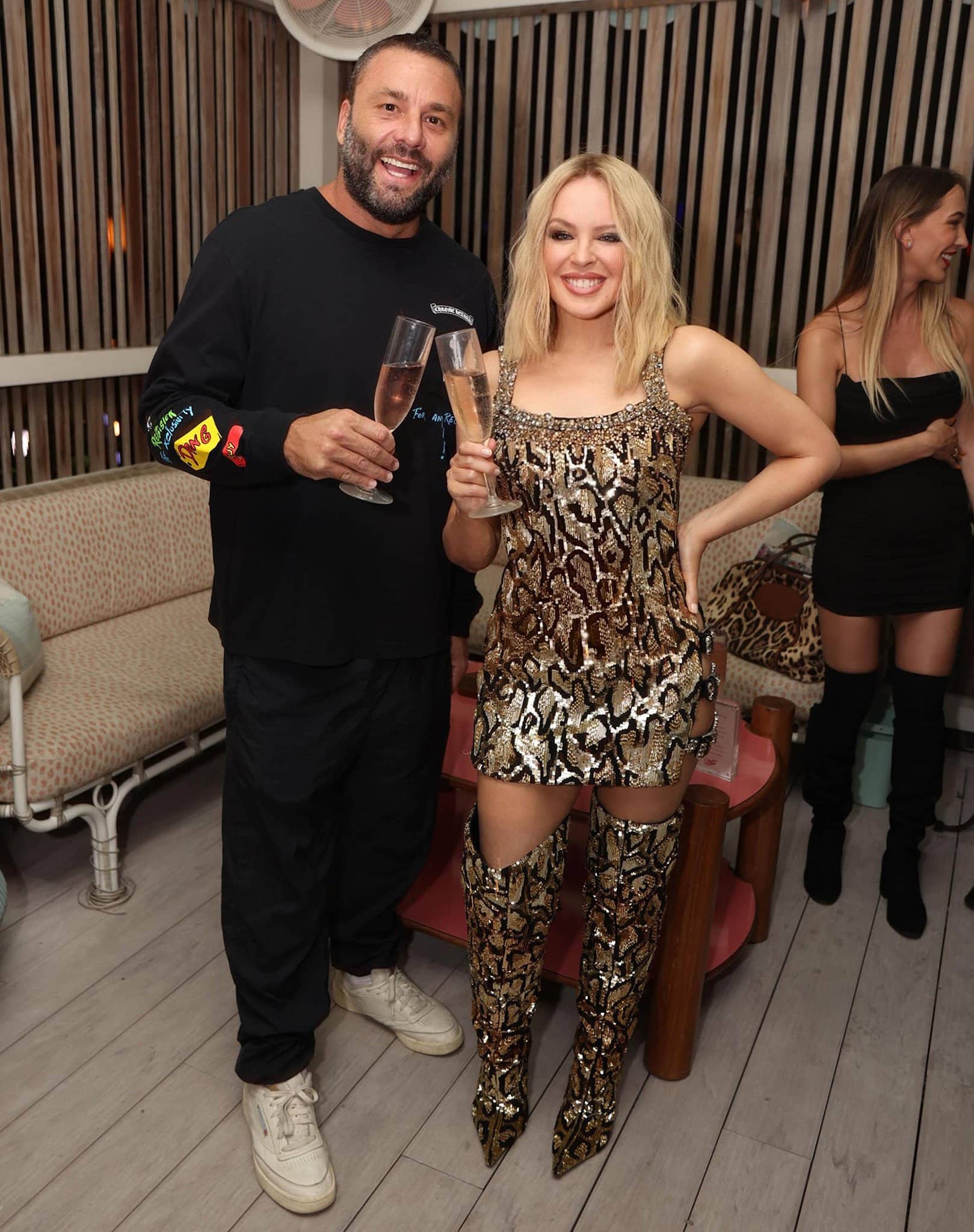 Joined by David Grutman, Kylie Minogue celebrates the launch of her eponymous range of wines to the US market in a Fausto Puglisi for Roberto Cavalli Fall 2022 snake outfit