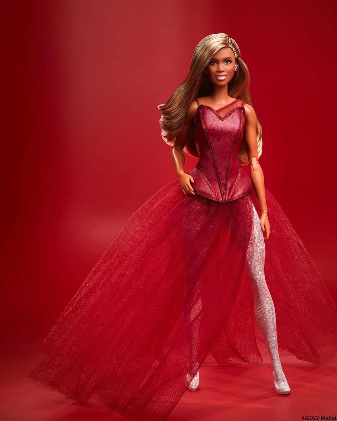 Laverne Cox is honored as the first transgender Barbie in a burgundy corset featuring a long, sheer skirt