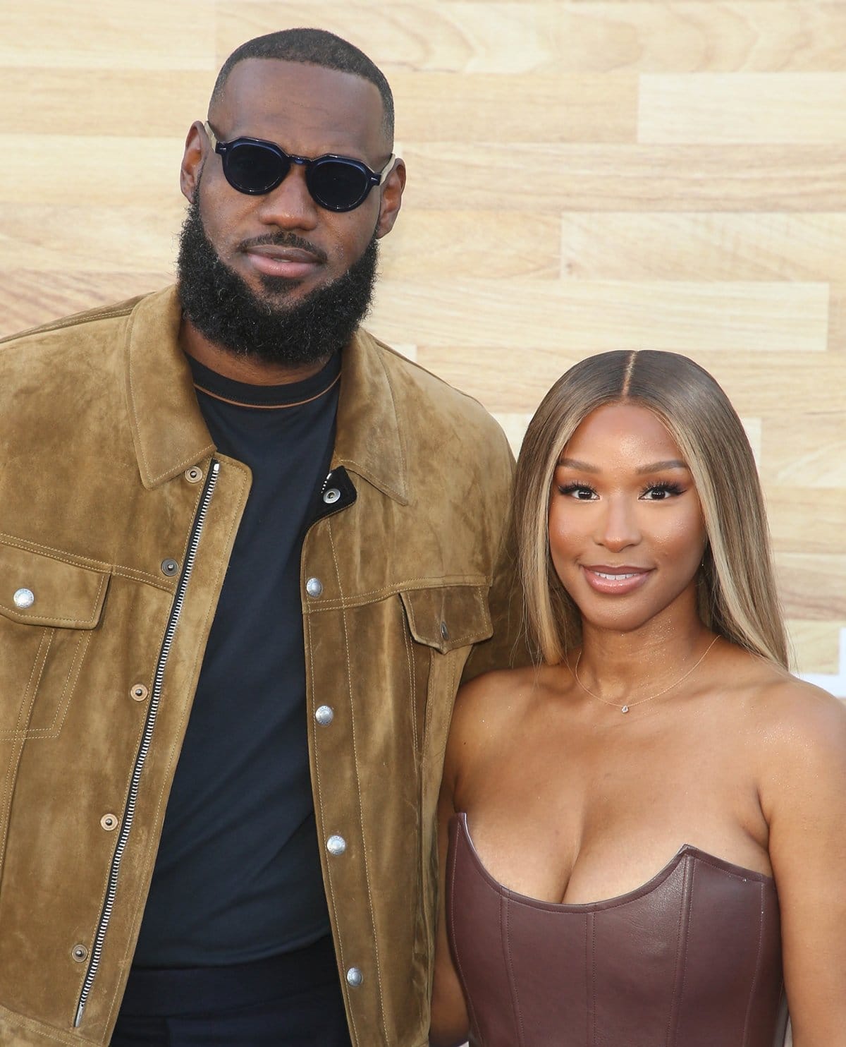 LeBron and Savannah James look effortlessly chic at the Netflix premiere of Hustle, with LeBron in a suede jacket and Savannah in a sleek brown leather bustier