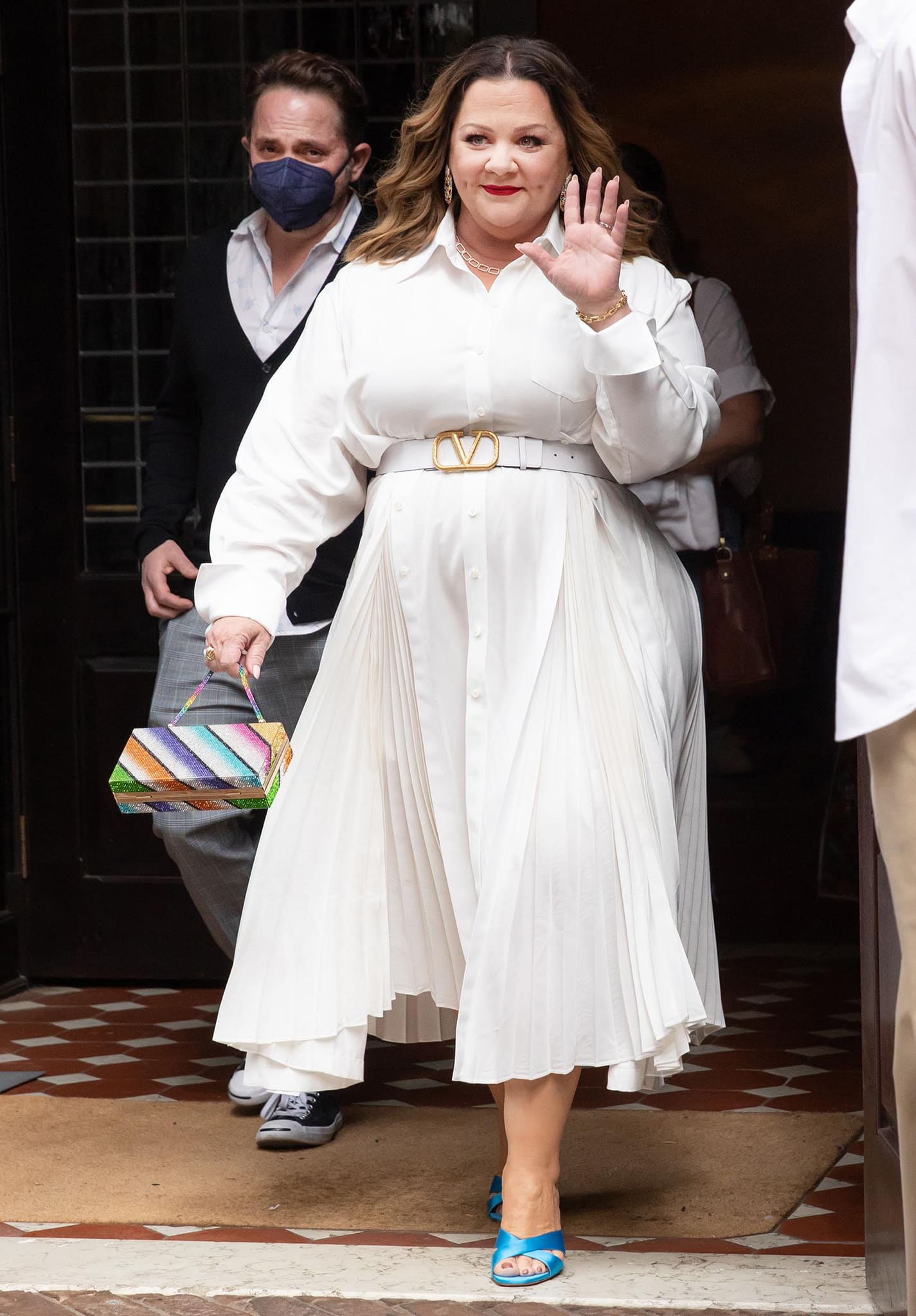 Melissa McCarthy wearing a white shirt dress with a Vlogo leather belt from Valentino