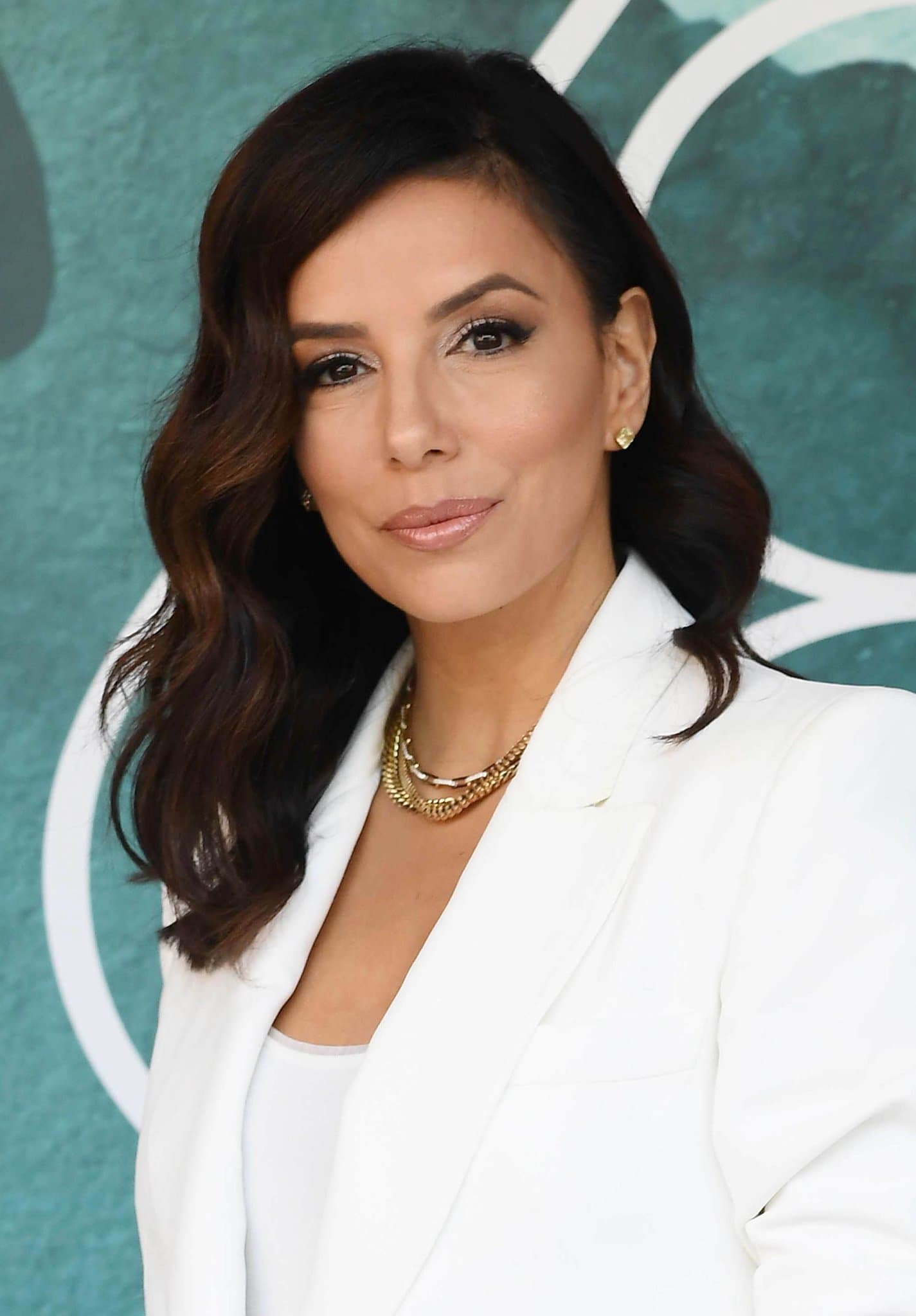 Eva Longoria parts her wavy tresses to the side and glams up with shimmering eyeshadow and dark mascara