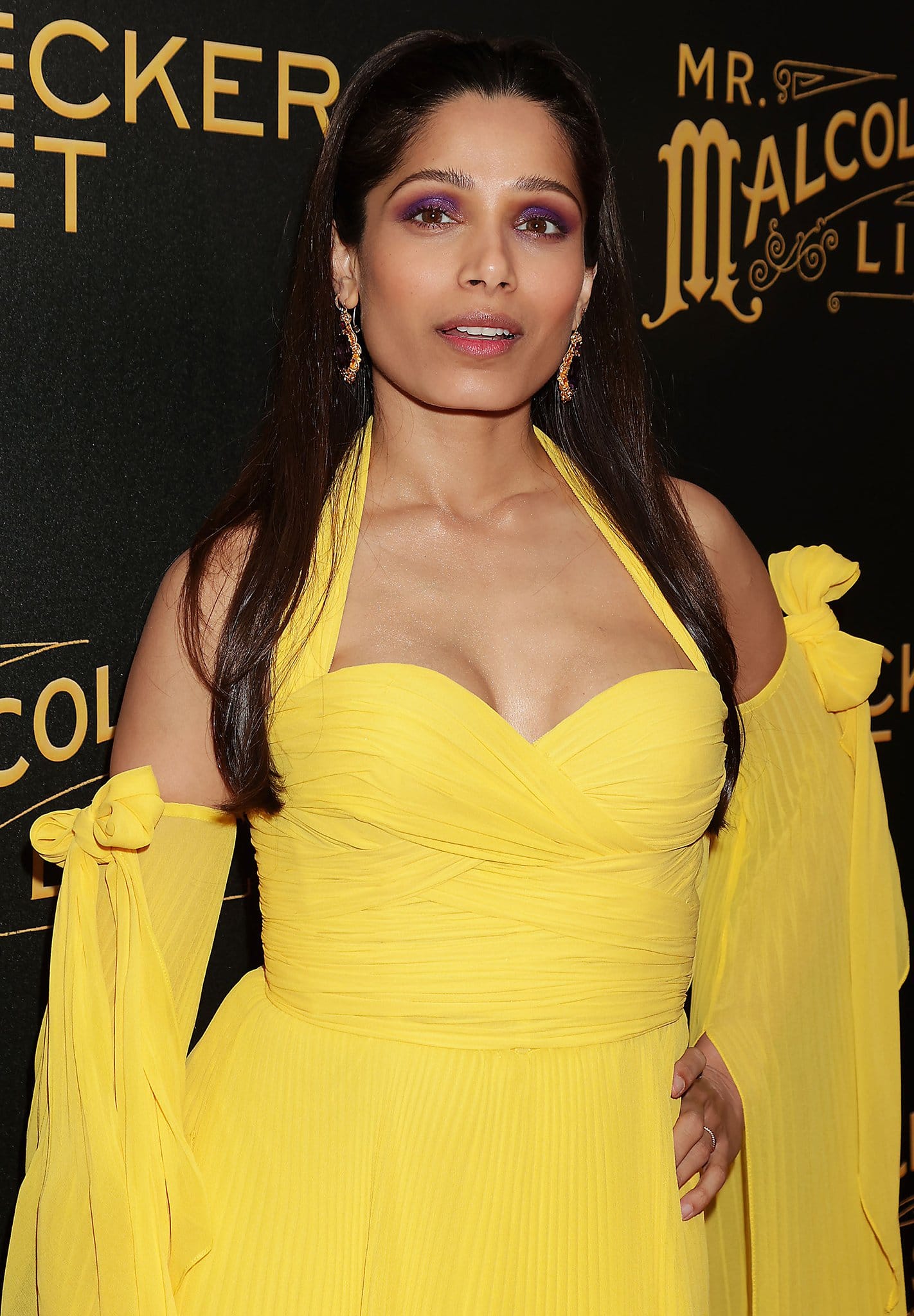 Freida Pinto styles her bright yellow gown with Fred Leighton 19th Century Amethyst earrings