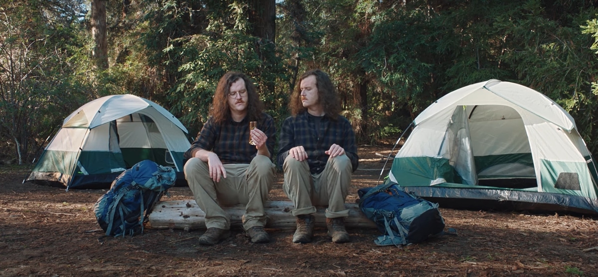 Two campers stare at a Twix bar and agree that it doesn't matter if you eat the left or right bar