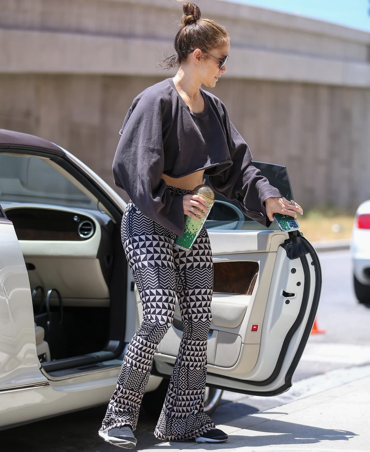Jennifer Lopez wearing a cropped sweatshirt with zigzag-print leggings and Nike Air sneakers