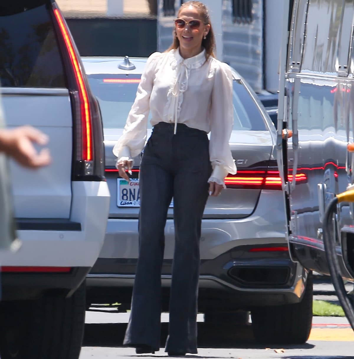 Jennifer Lopez wearing a white blouse and Grey Ant flared jeans
