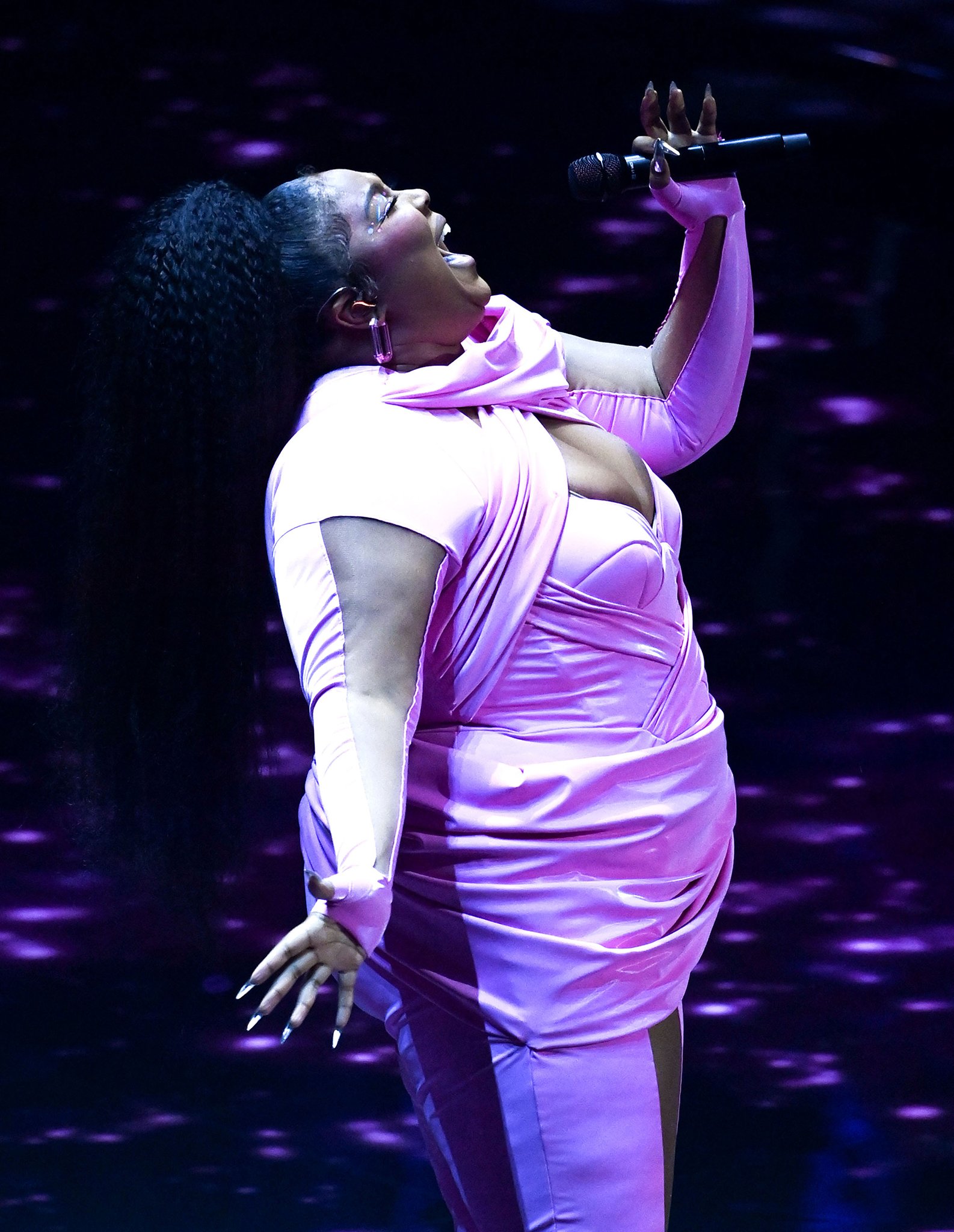 Lizzo wears a bubblegum pink outfit by Rey Ortiz for her performance