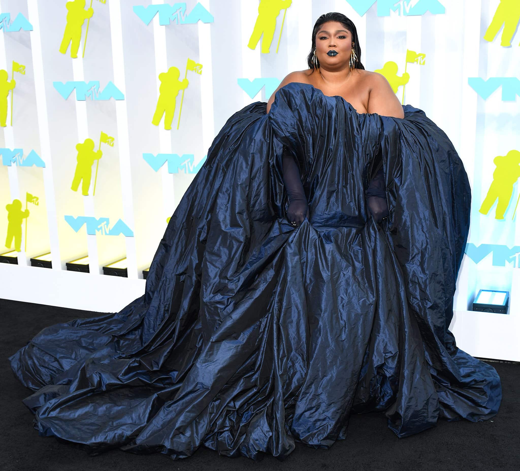Lizzo arrives on the red carpet in a voluminous iridescent navy gown by Glenn Martens for Jean Paul Gaultier’s Spring/Summer 2022 Couture collection