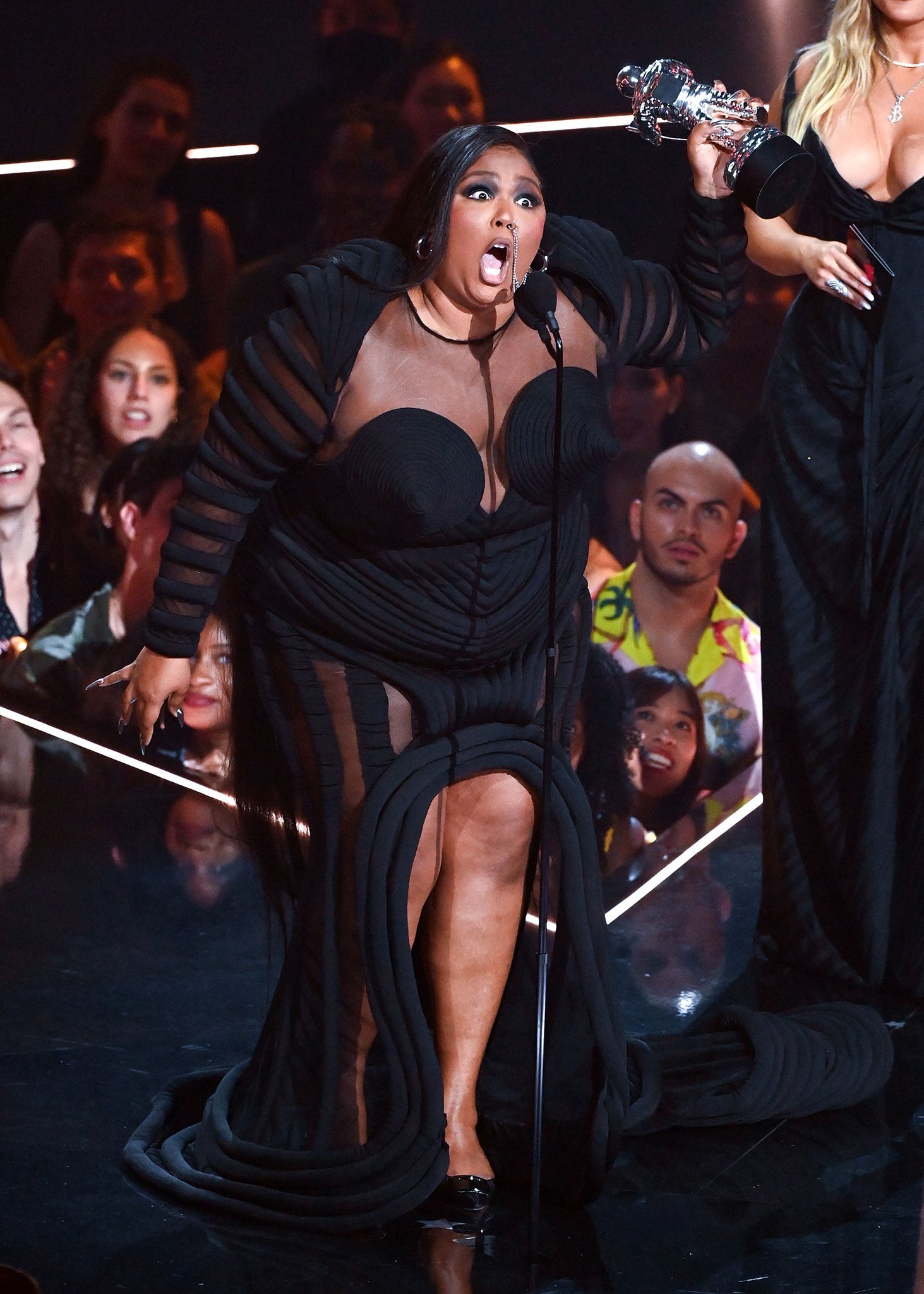Lizzo looks confident as she shows off her voluptuous curves in a Jean Paul Gaultier Fall 2022 black mesh gown