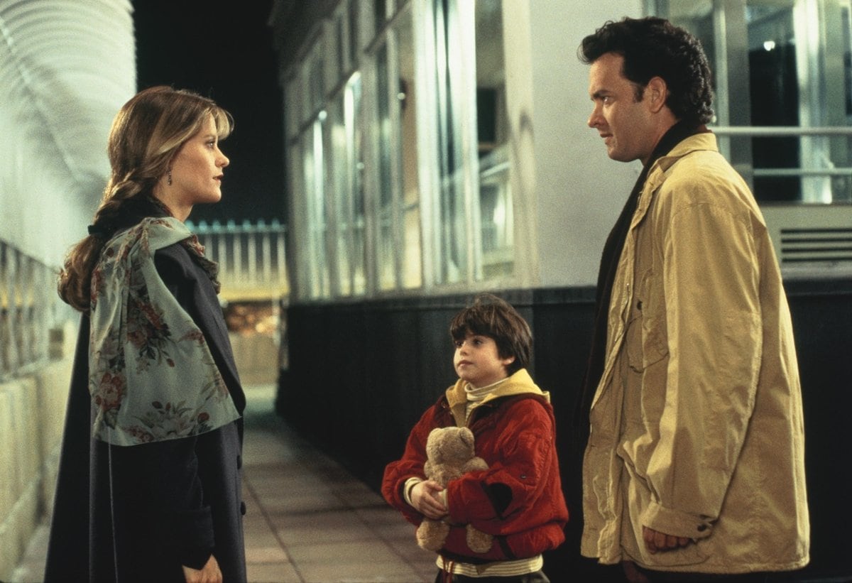 Tom Hanks as Sam Baldwin, Meg Ryan as Annie Reed, and Ross Malinger as Jonah Baldwin in the 1993 American romantic comedy-drama film Sleepless in Seattle