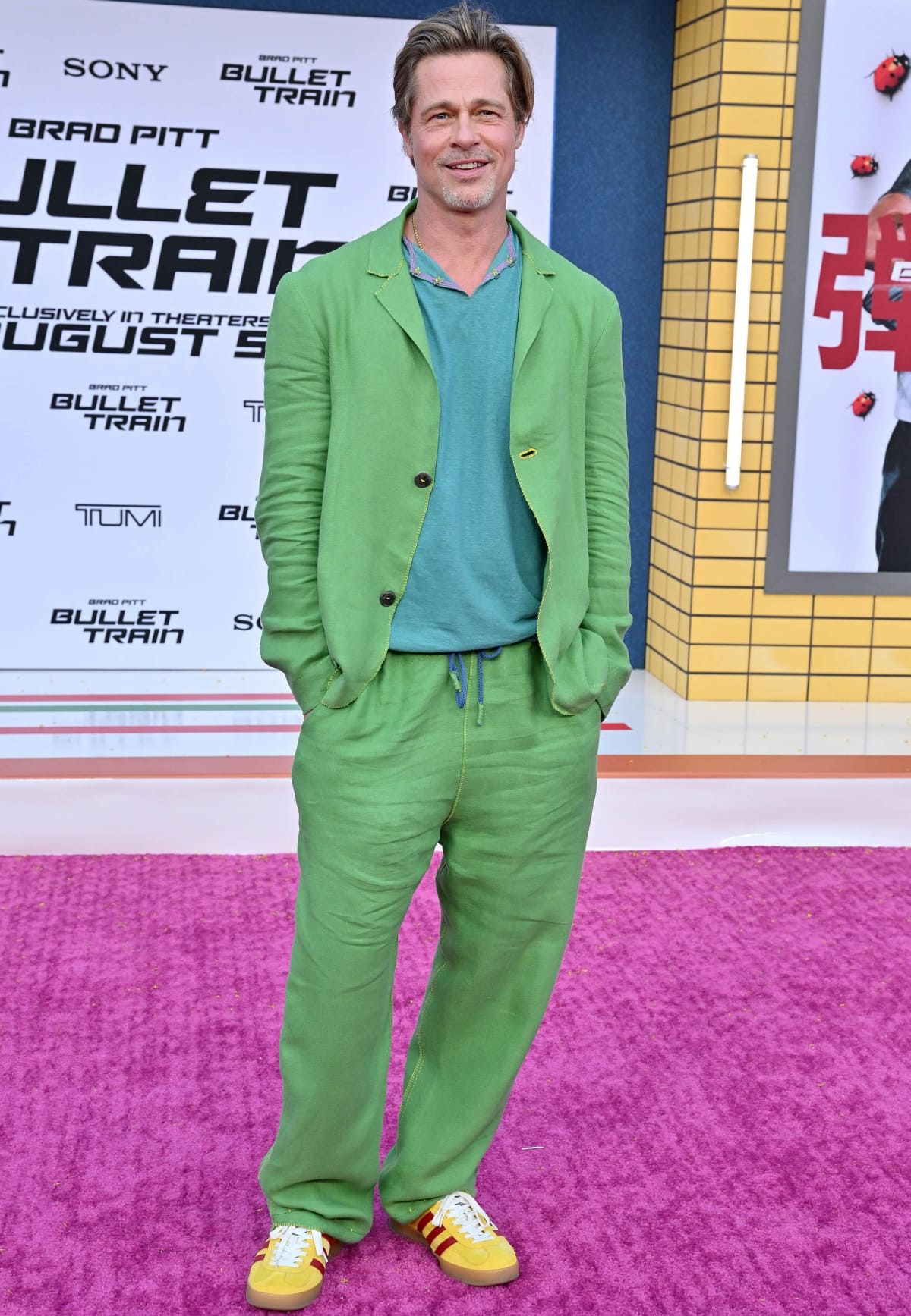 Brad Pitt wearing a custom Haans Nicholas Mott green linen suit with Gucci x Adidas yellow sneakers