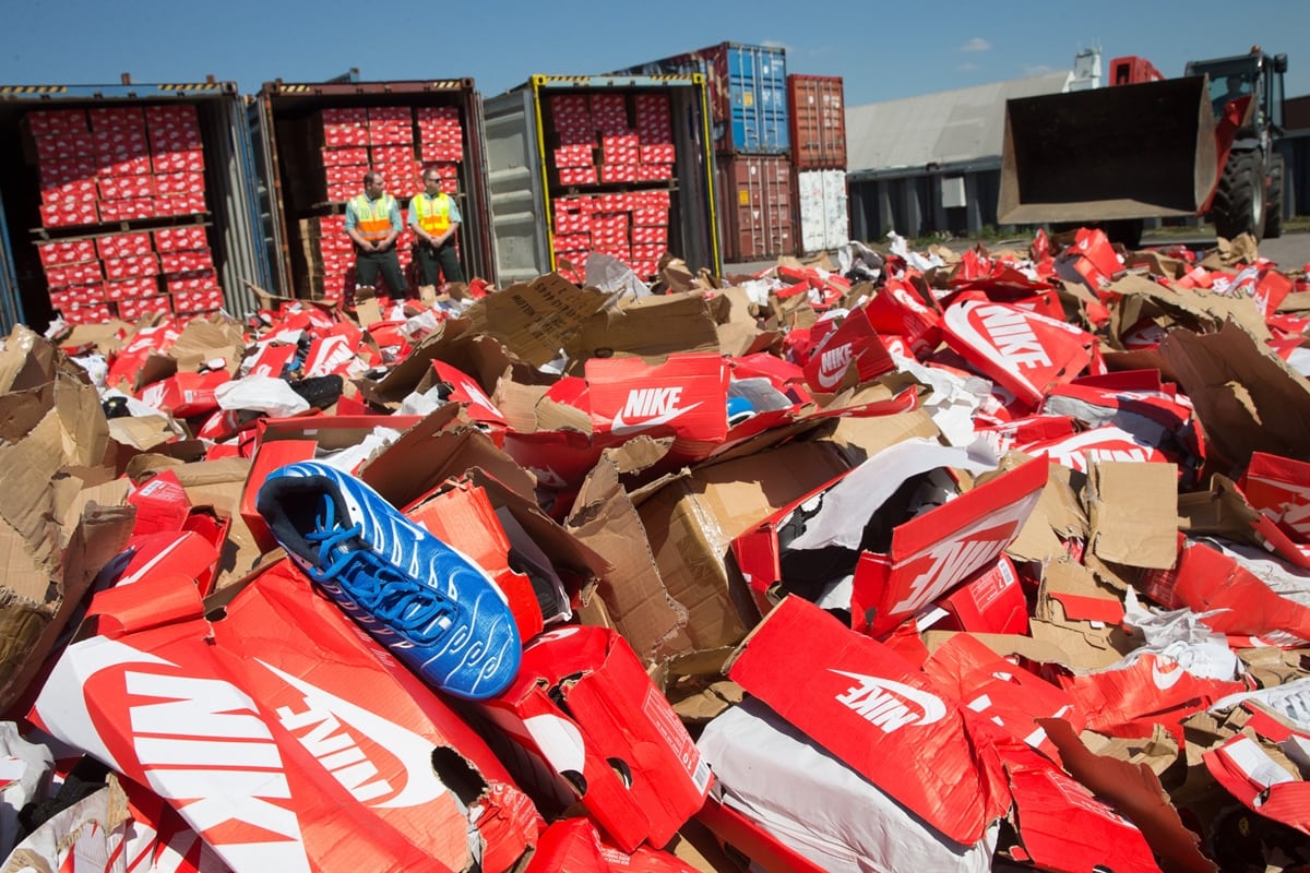Custom officers controlling the destruction of tens of thousands of fake brand sports shoes
