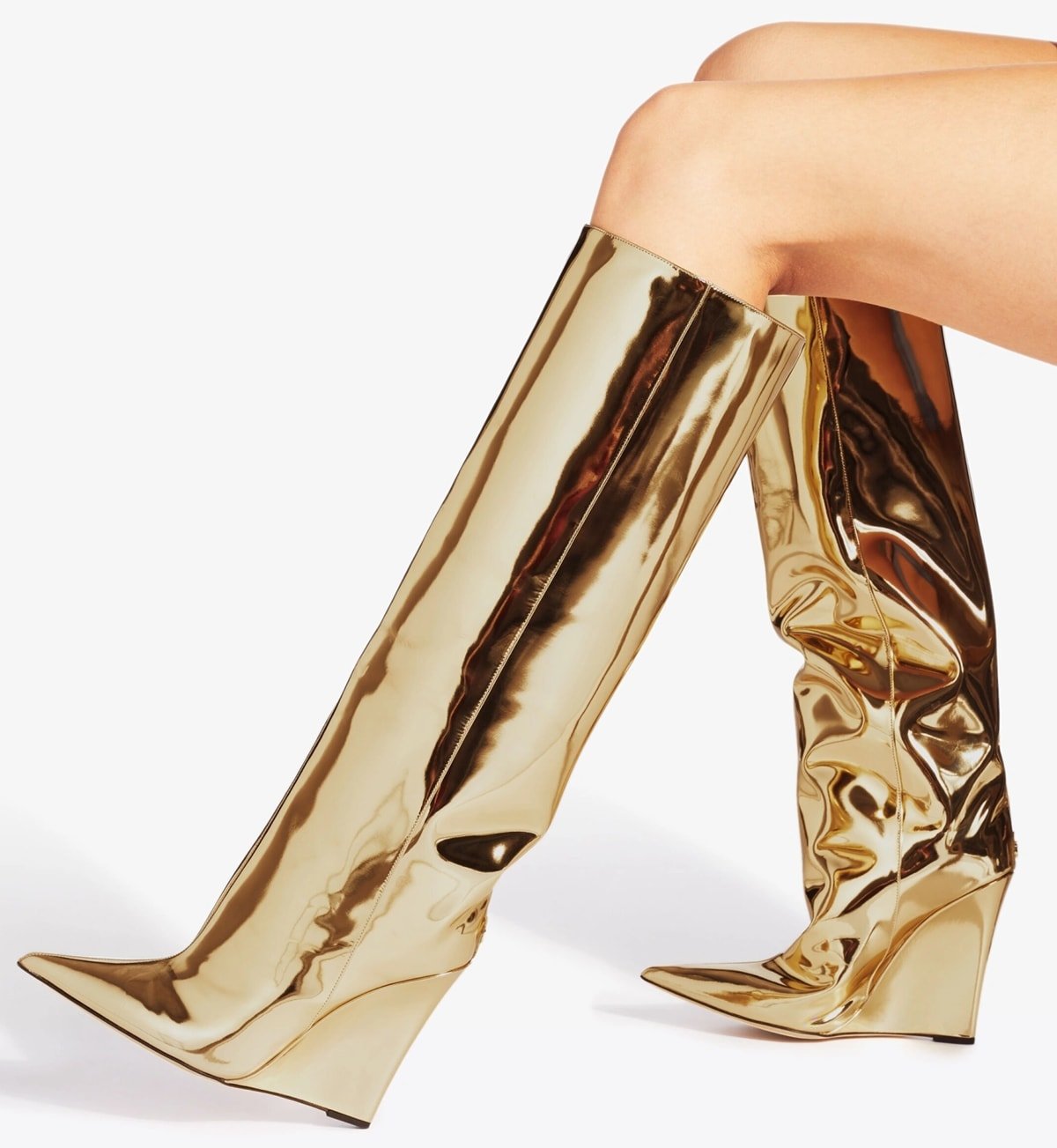 These gold liquid metal leather boots have sculptural wedge heels that create the illusion of a stiletto from the back and a wedge from the side